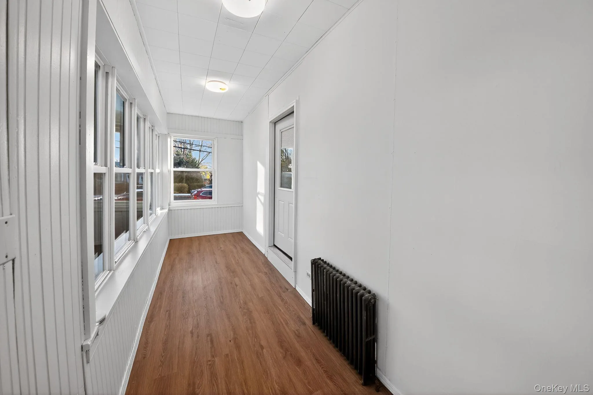 Hallway with radiator heating unit and wood finished floors Hallway with radiator heating unit and wood finished floors