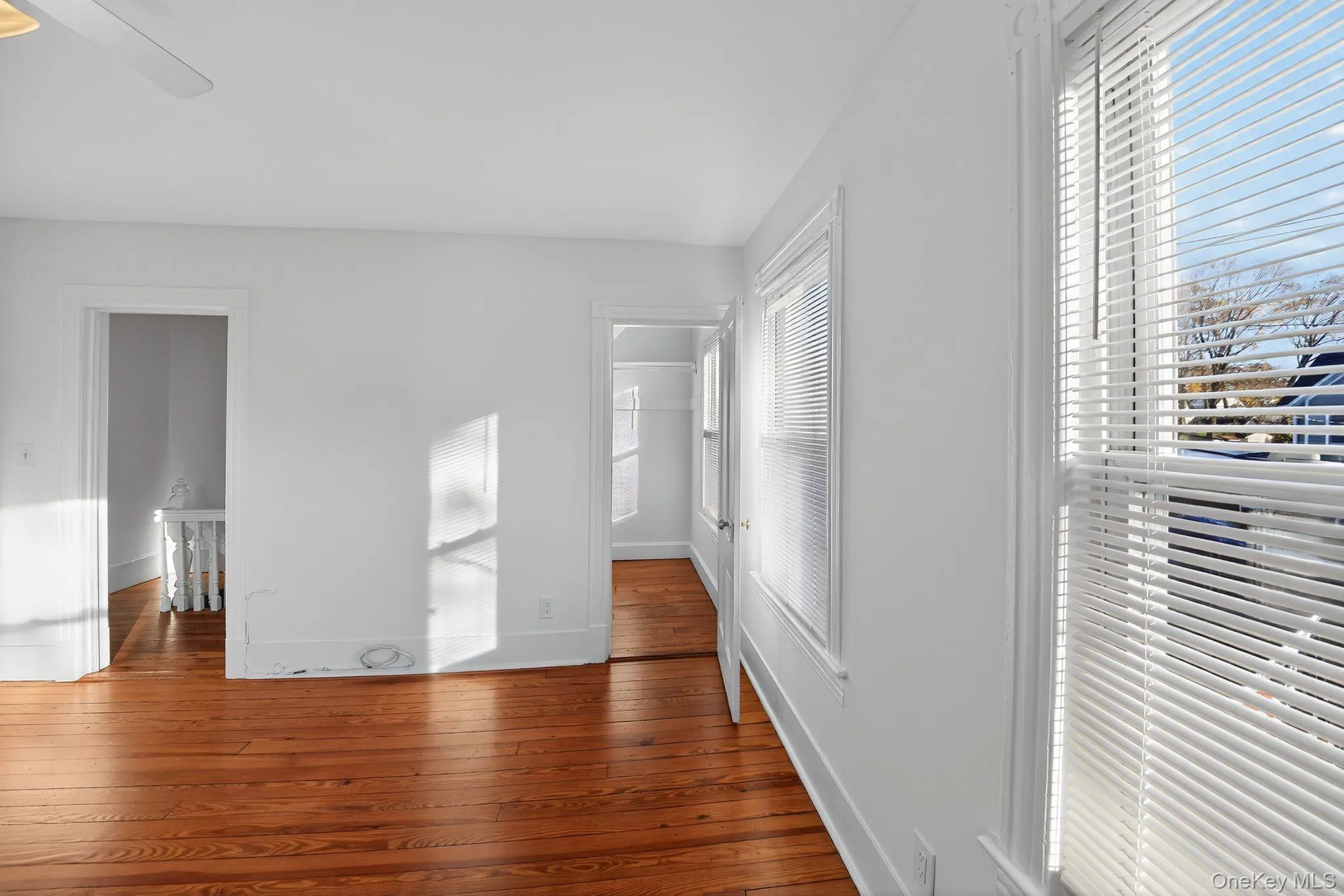 Unfurnished bedroom featuring wood-type flooring and ceiling fan Unfurnished bedroom featuring wood-type flooring and ceiling fan