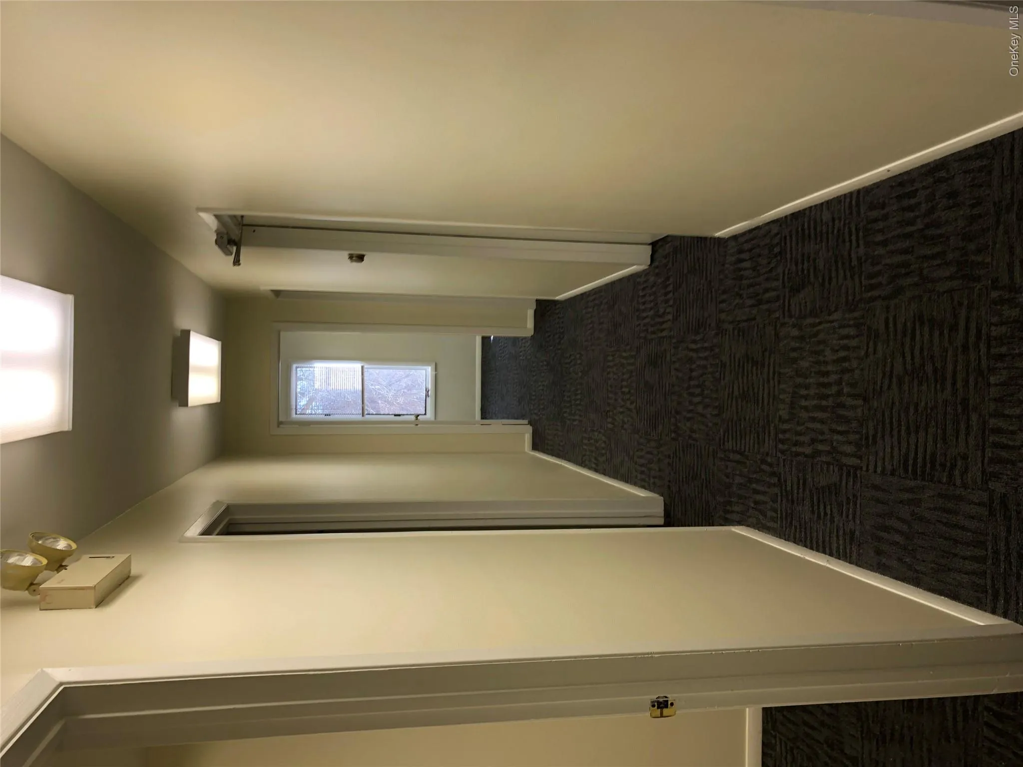 Corridor featuring dark carpet and baseboards Corridor featuring dark carpet and baseboards
