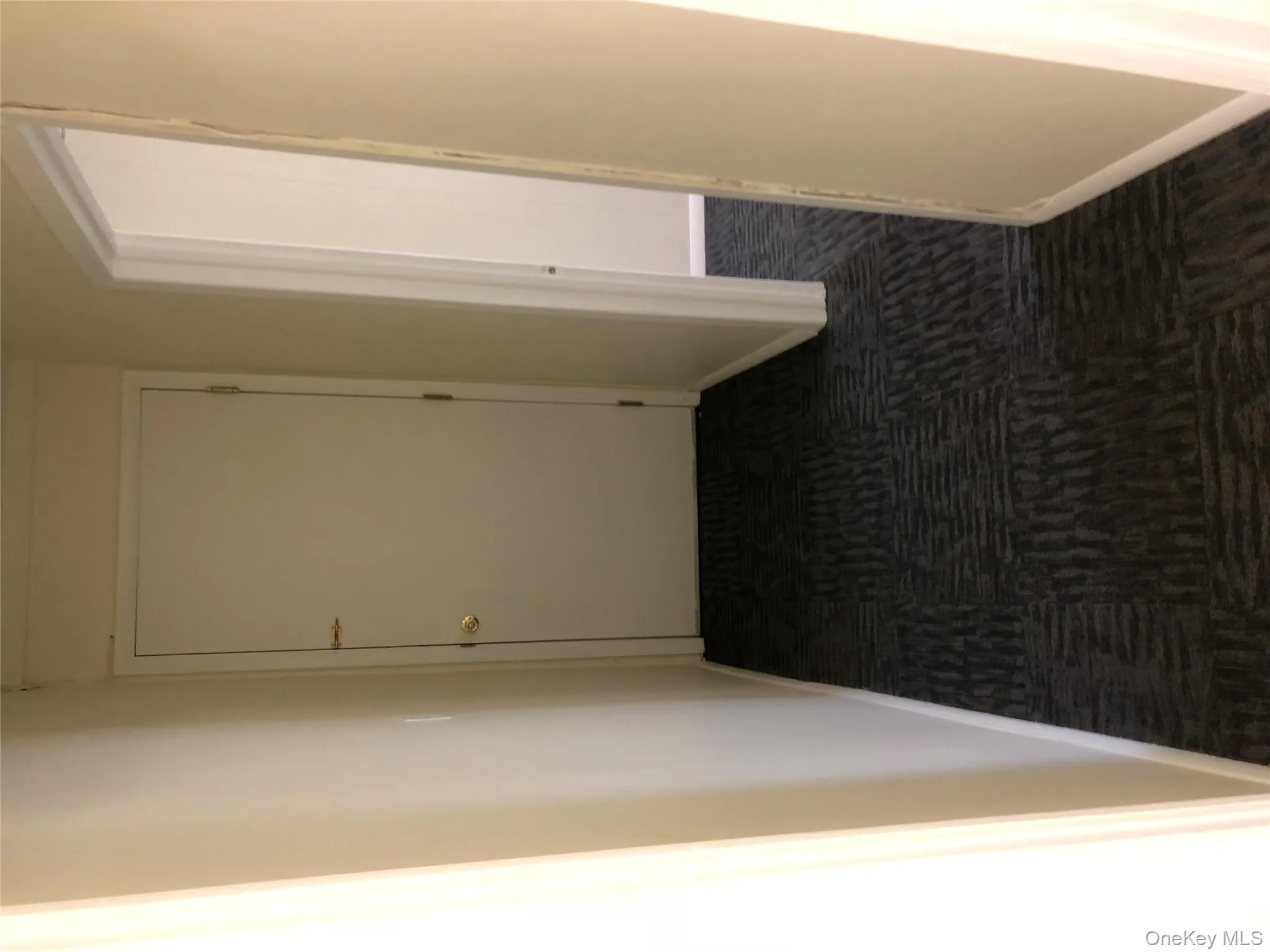 Hallway with dark colored carpet and baseboards Hallway with dark colored carpet and baseboards