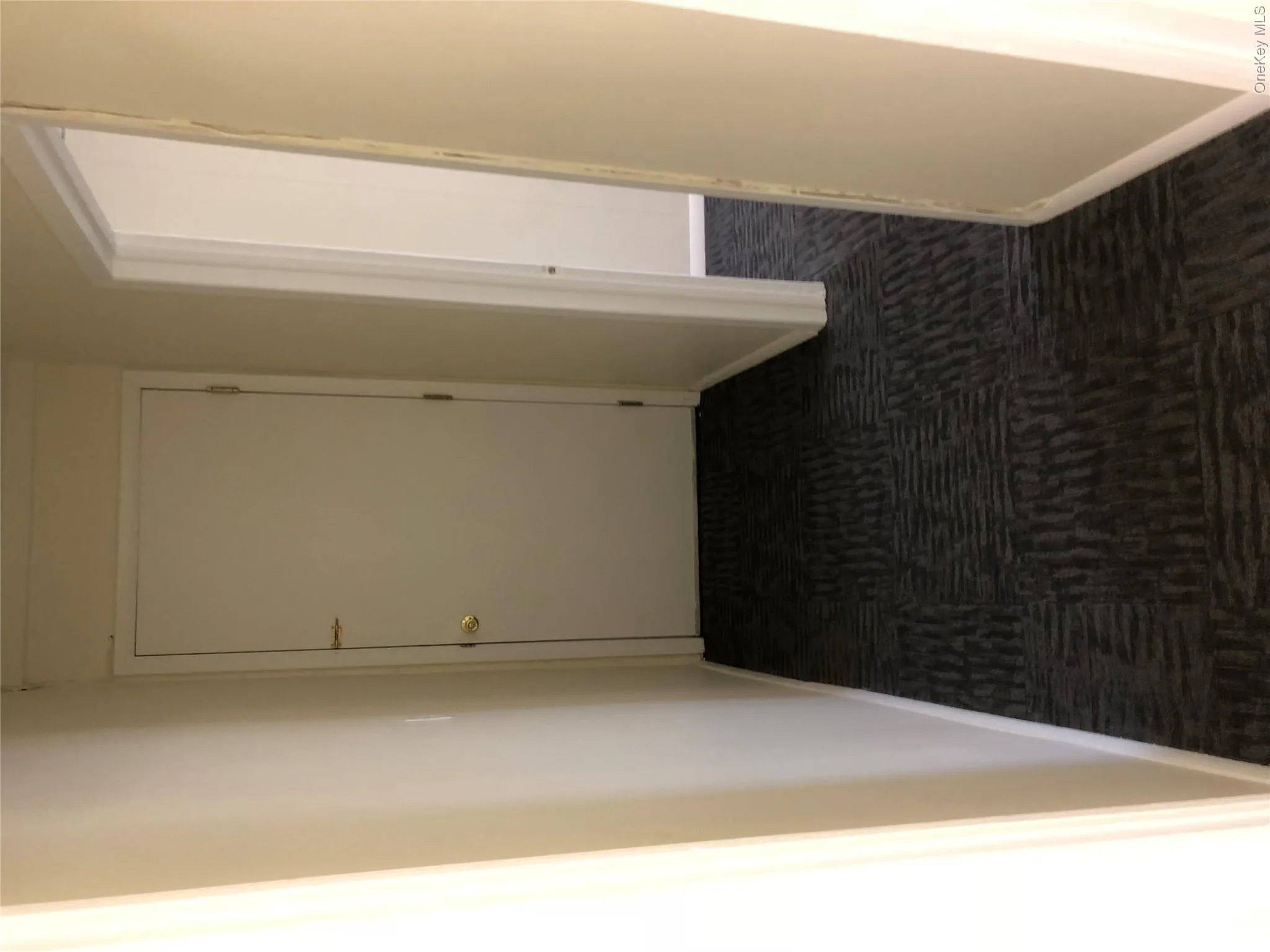 Hallway with dark colored carpet and baseboards Hallway with dark colored carpet and baseboards