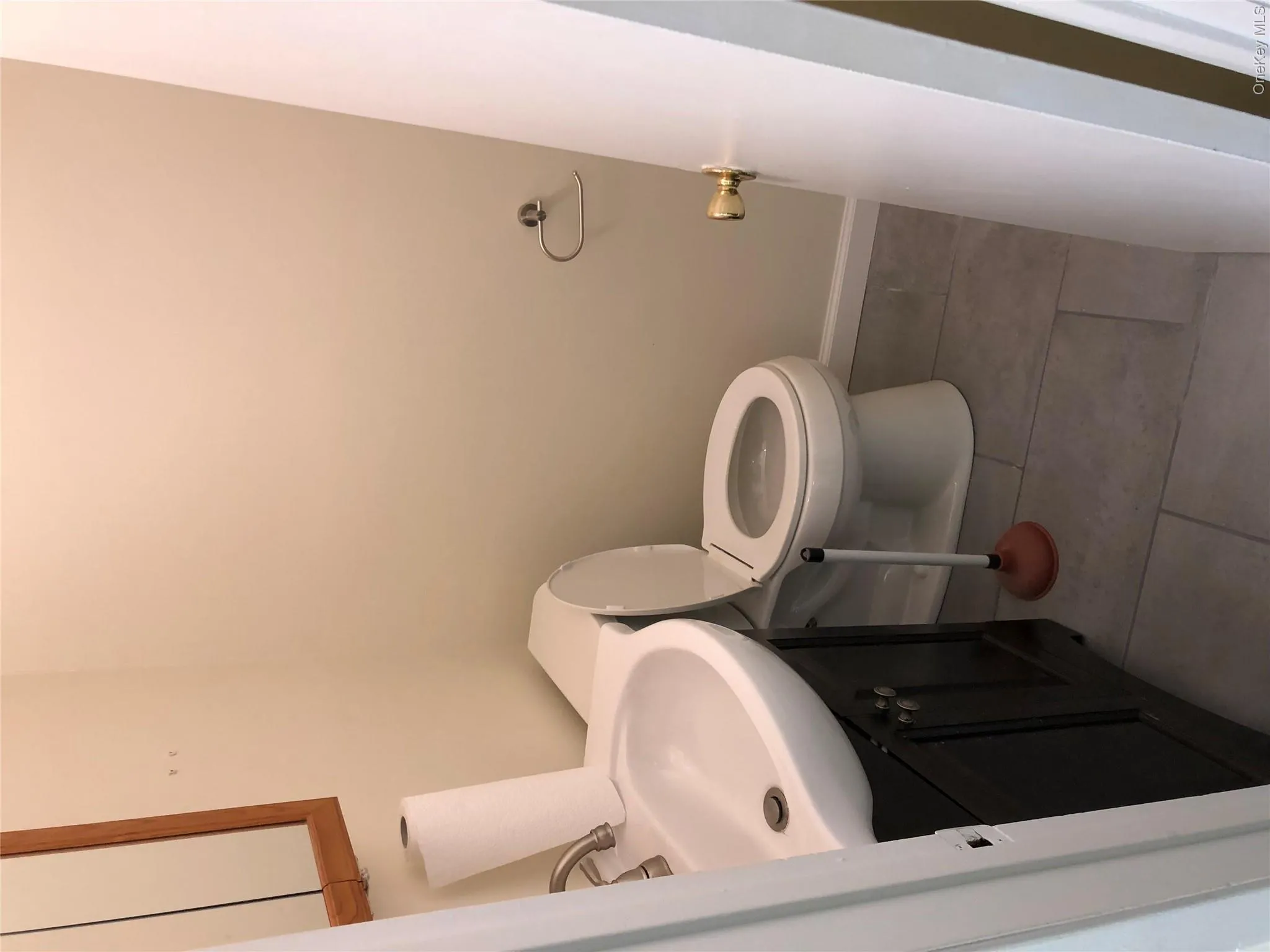 Half bathroom with vanity and light tile patterned flooring Half bathroom with vanity and light tile patterned flooring