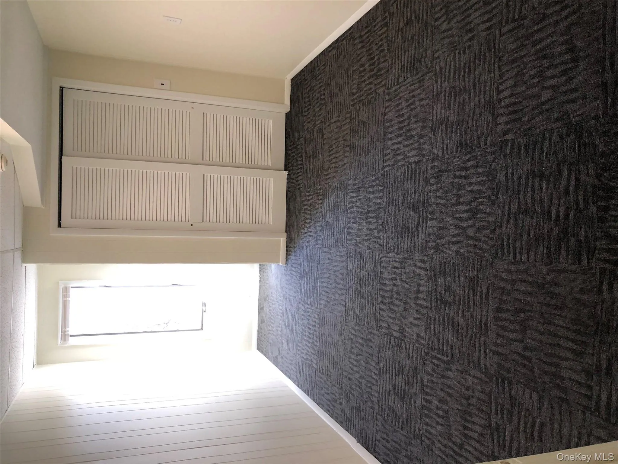 Unfurnished bedroom with a closet and dark colored carpet Unfurnished bedroom with a closet and dark colored carpet