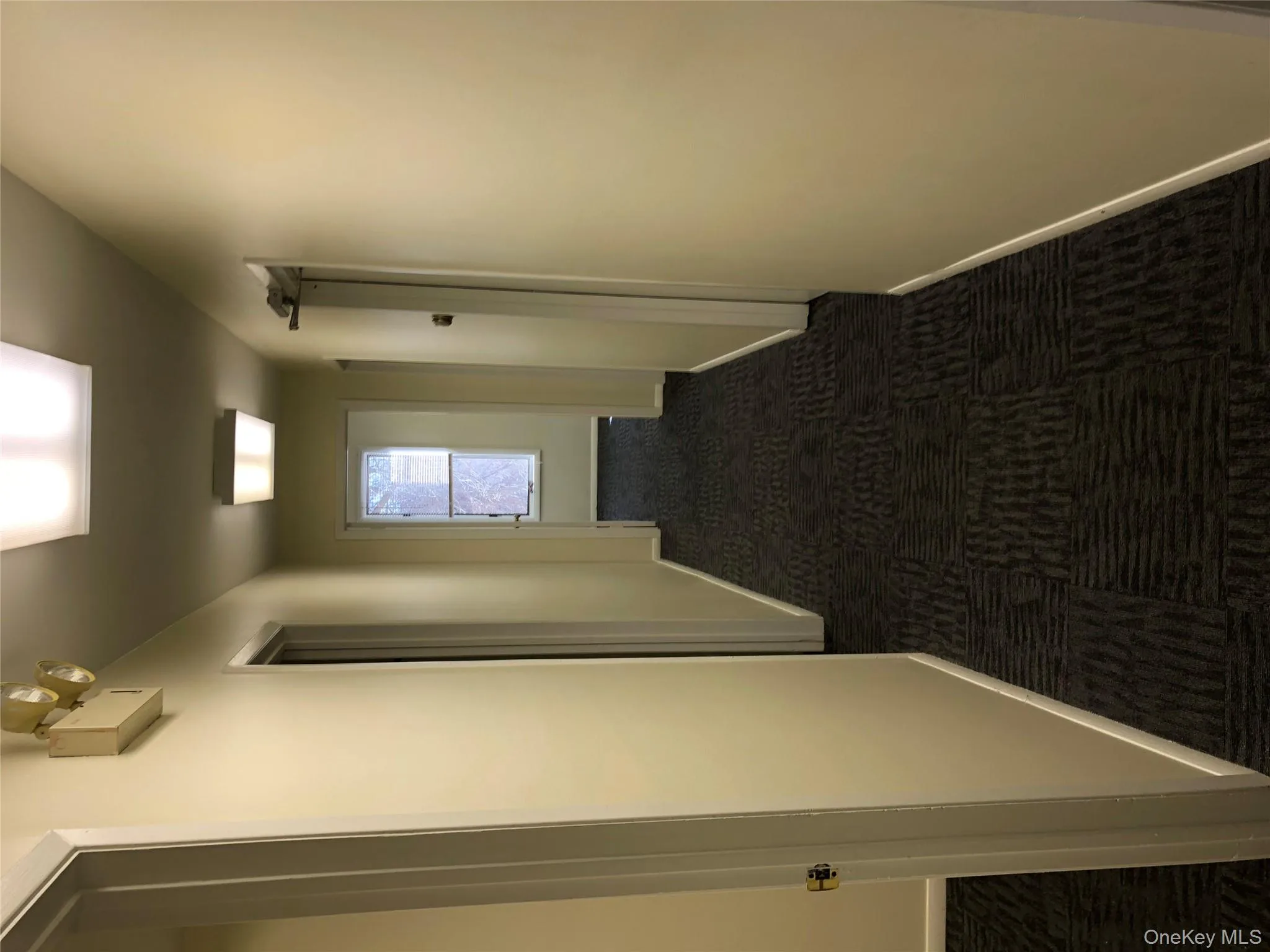 Corridor featuring dark carpet and baseboards Corridor featuring dark carpet and baseboards