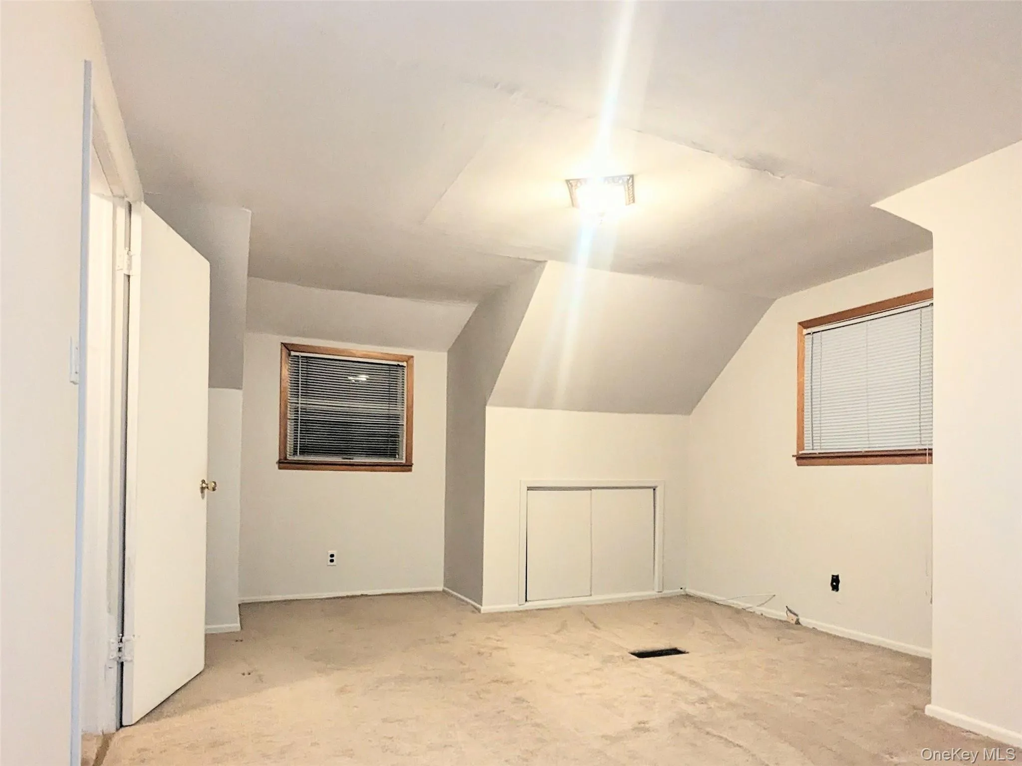 Additional living space with lofted ceiling and carpet flooring Additional living space with lofted ceiling and carpet flooring