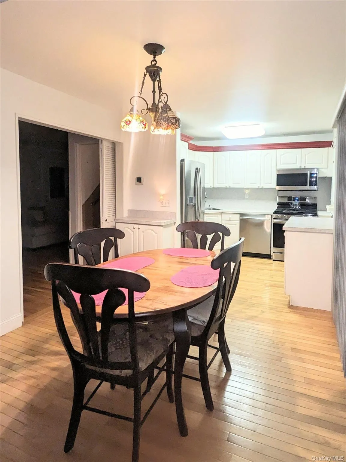 Dining space featuring light wood-type flooring and a chandelier Dining space featuring light wood-type flooring and a chandelier
