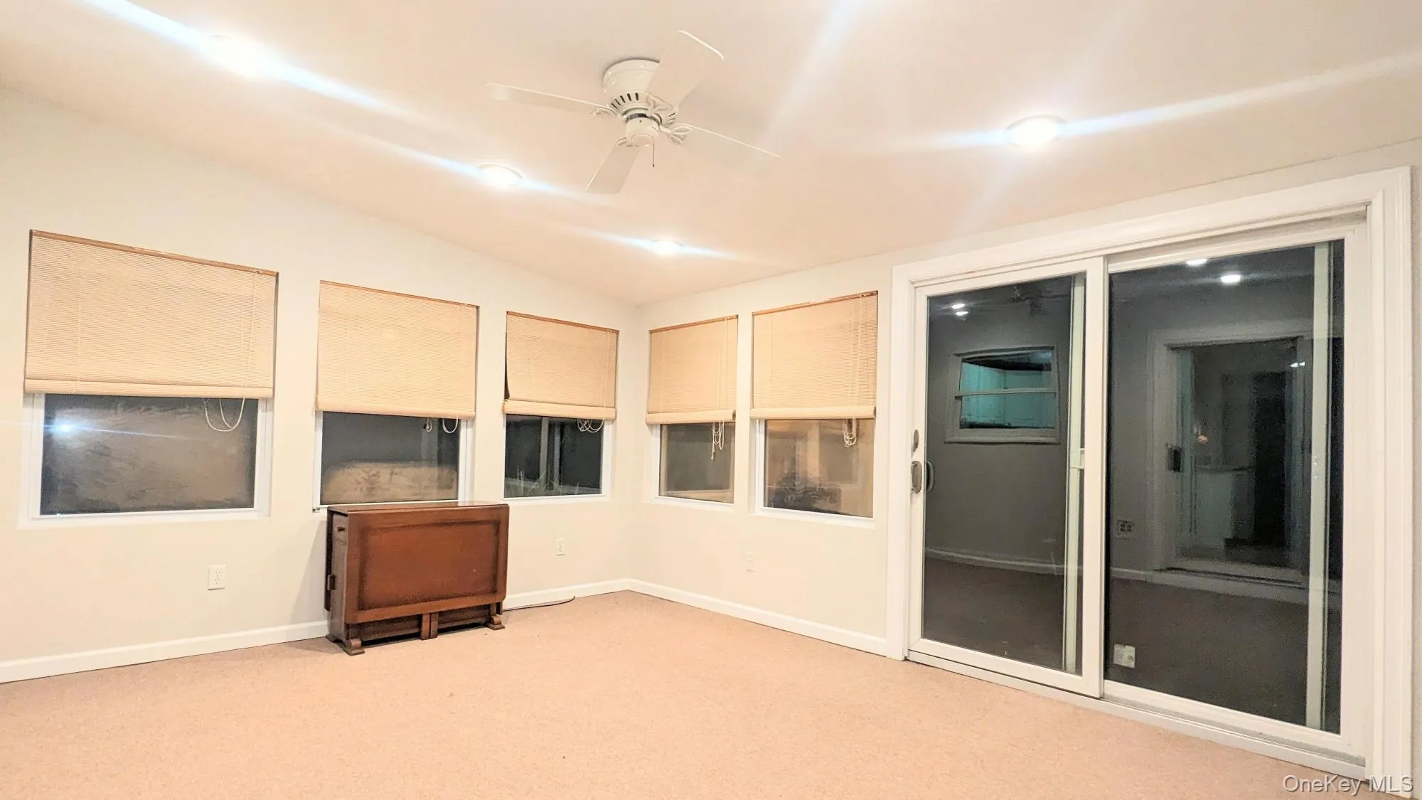 Empty room featuring lofted ceiling, ceiling fan, and carpet floors Empty room featuring lofted ceiling, ceiling fan, and carpet floors