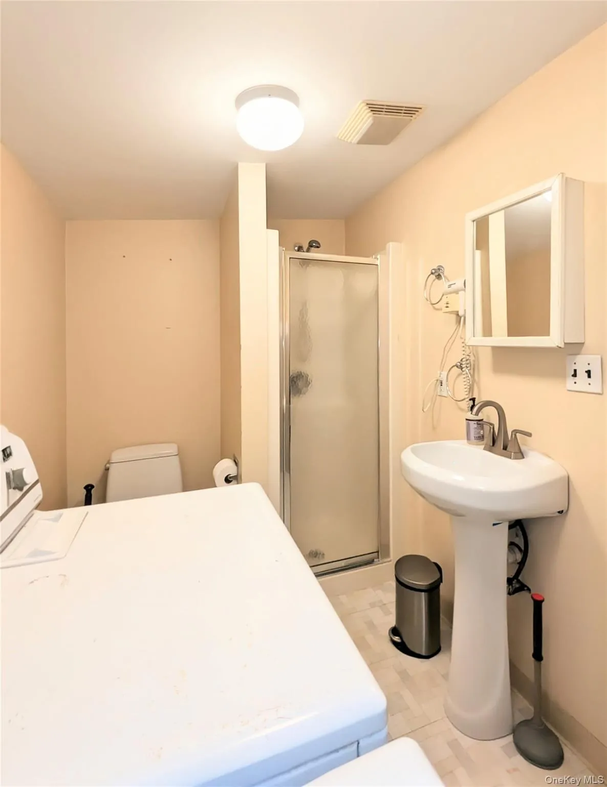 Bathroom with washer / dryer and a shower stall Bathroom with washer / dryer and a shower stall