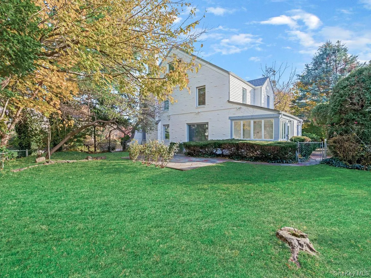 Rear view of house featuring brick siding and a sunroom Rear view of house featuring brick siding and a sunroom