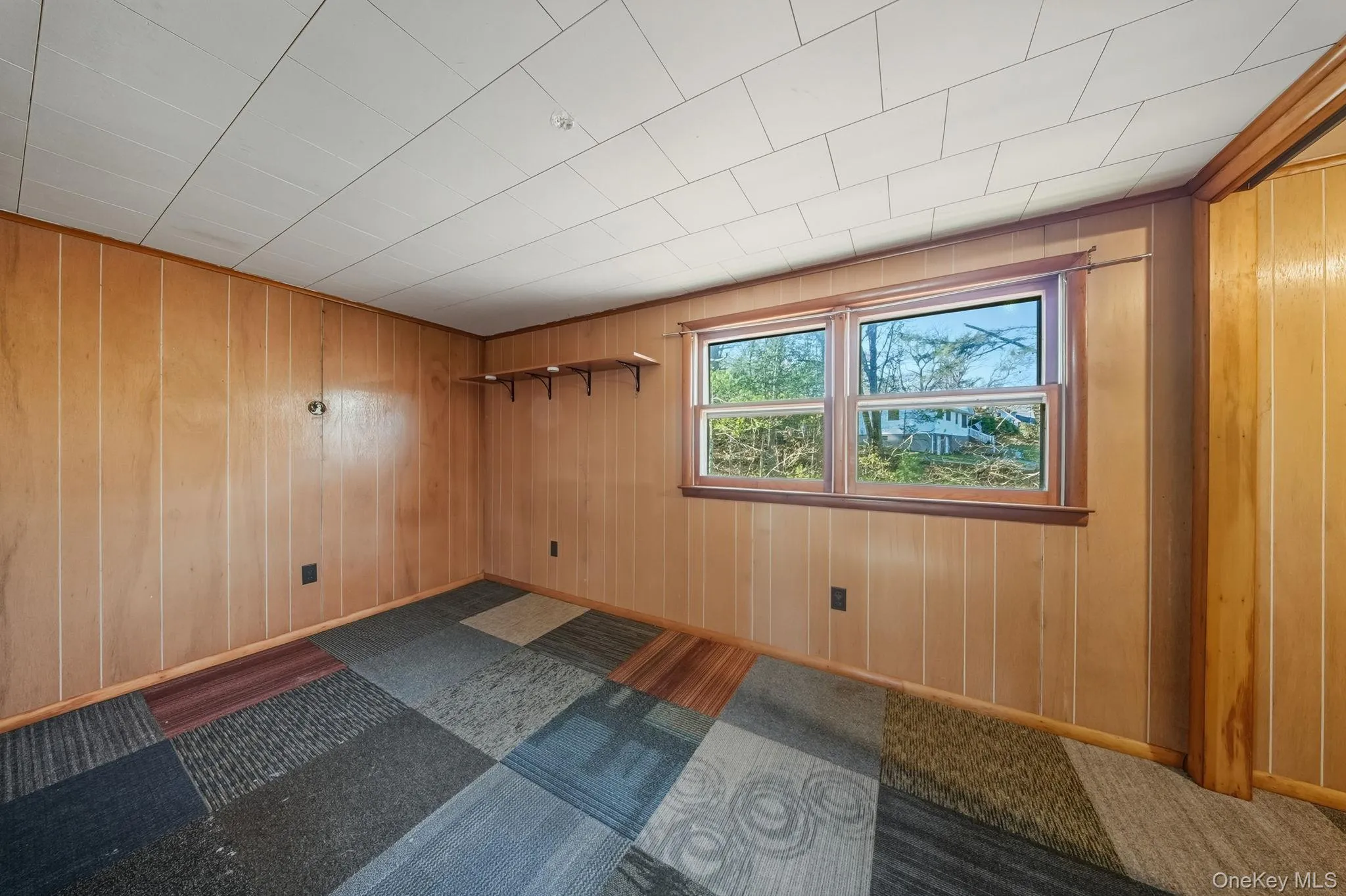 Unfurnished room featuring wooden walls Unfurnished room featuring wooden walls