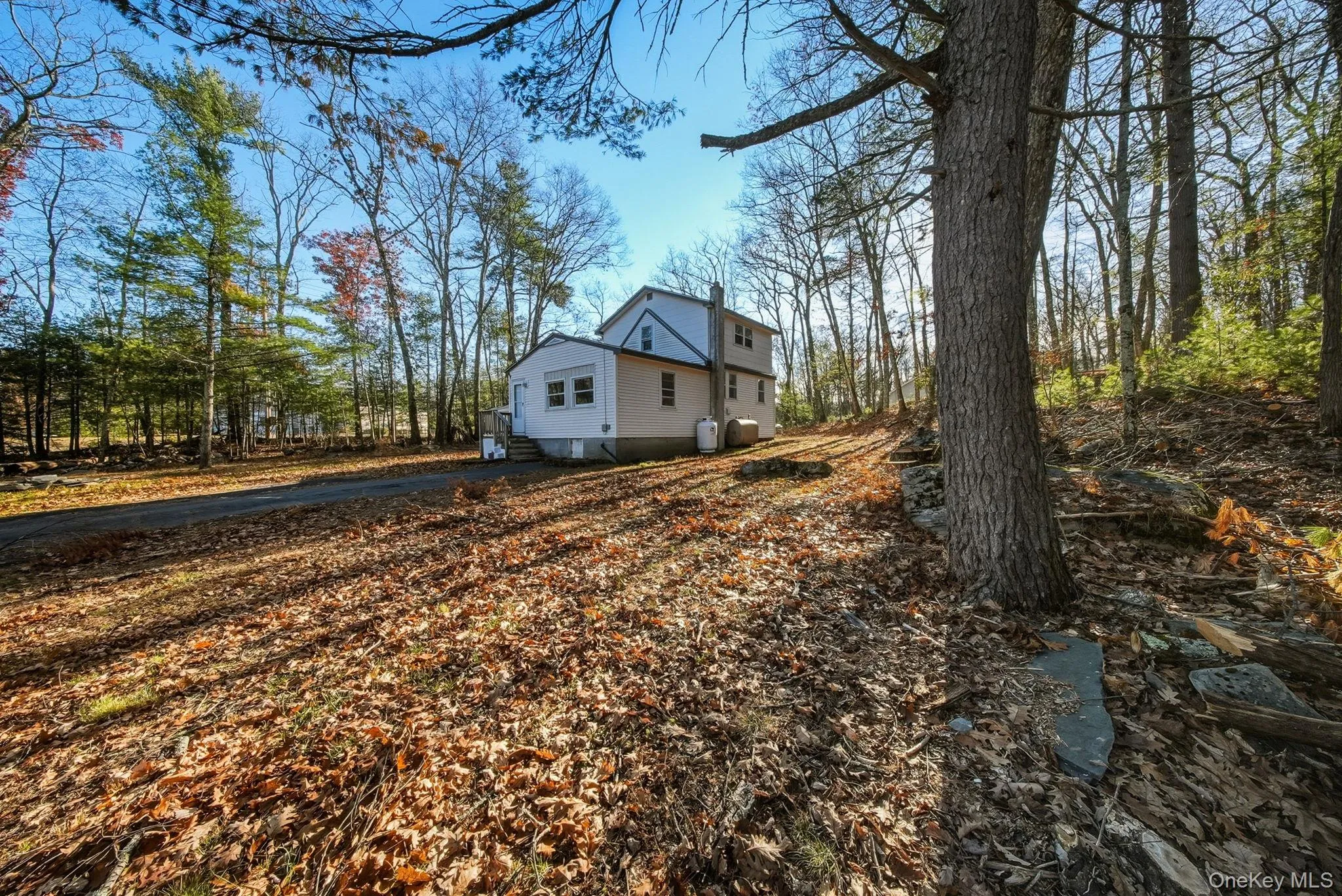 View of side of home featuring asphalt driveway View of side of home featuring asphalt driveway