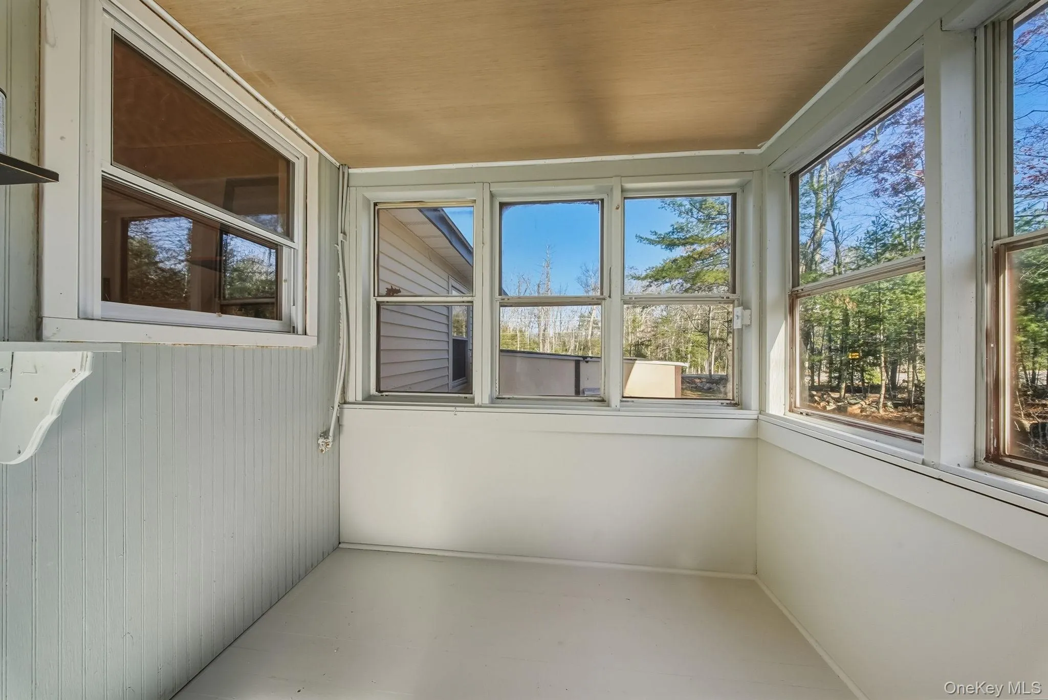 Unfurnished sunroom featuring wooden ceiling and wooden walls Unfurnished sunroom featuring wooden ceiling and wooden walls