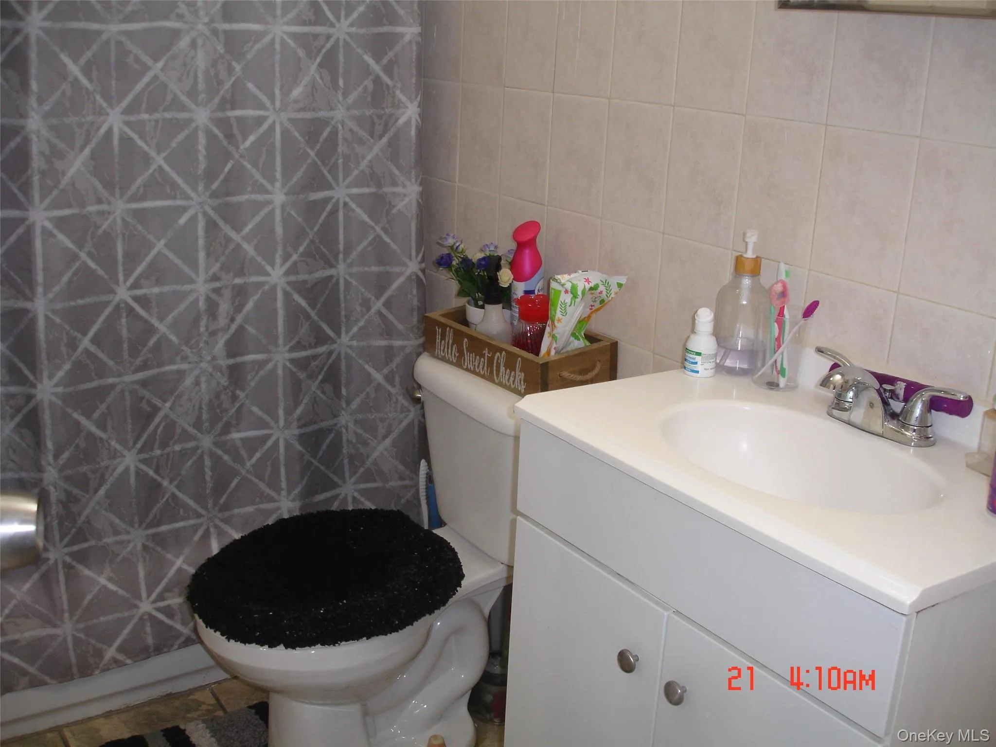 Bathroom featuring tile walls, vanity, a shower with shower curtain, and tile patterned flooring Bathroom featuring tile walls, vanity, a shower with shower curtain, and tile patterned flooring