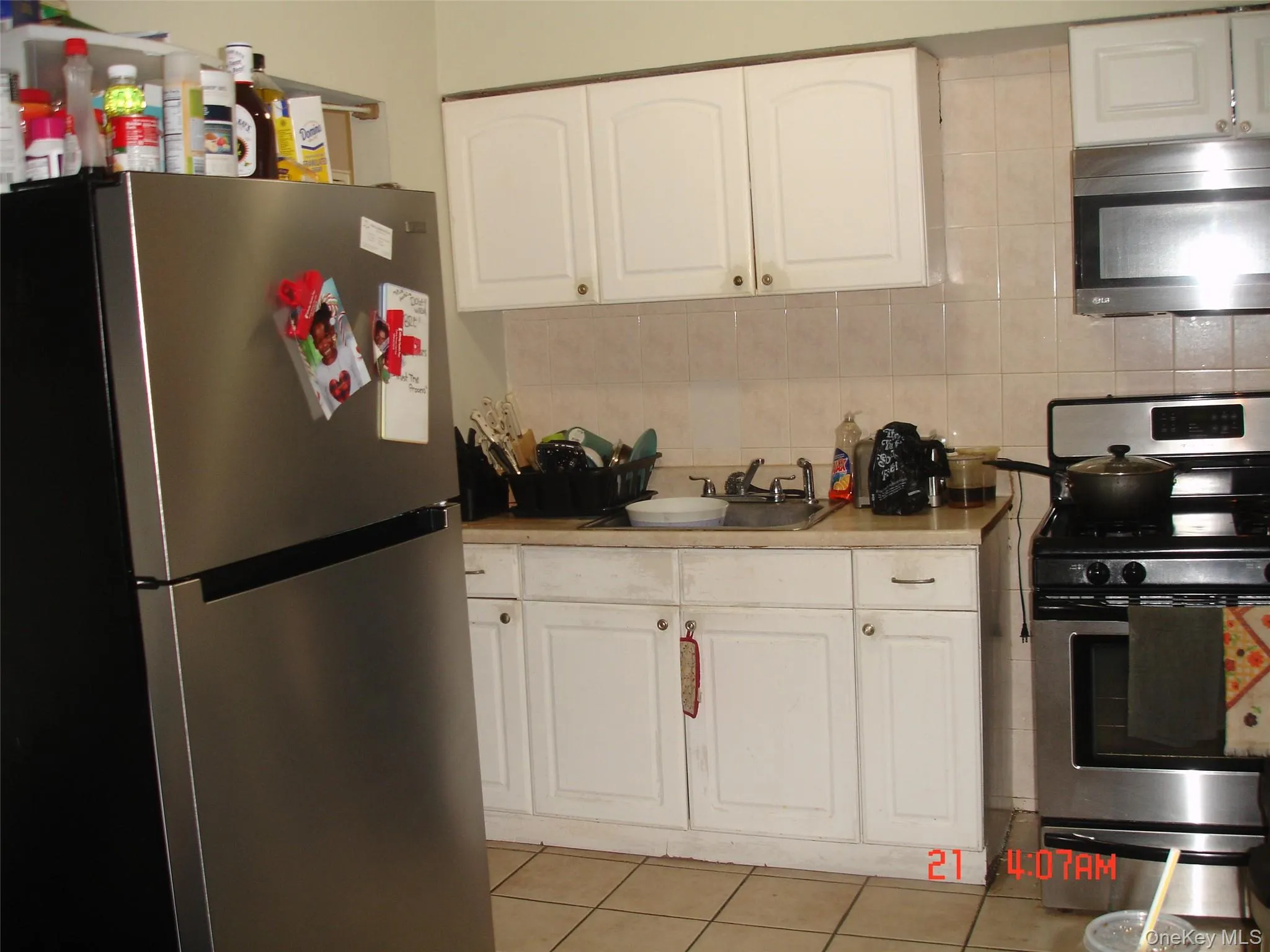 Kitchen with appliances with stainless steel finishes, white cabinetry, and tasteful backsplash Kitchen with appliances with stainless steel finishes, white cabinetry, and tasteful backsplash
