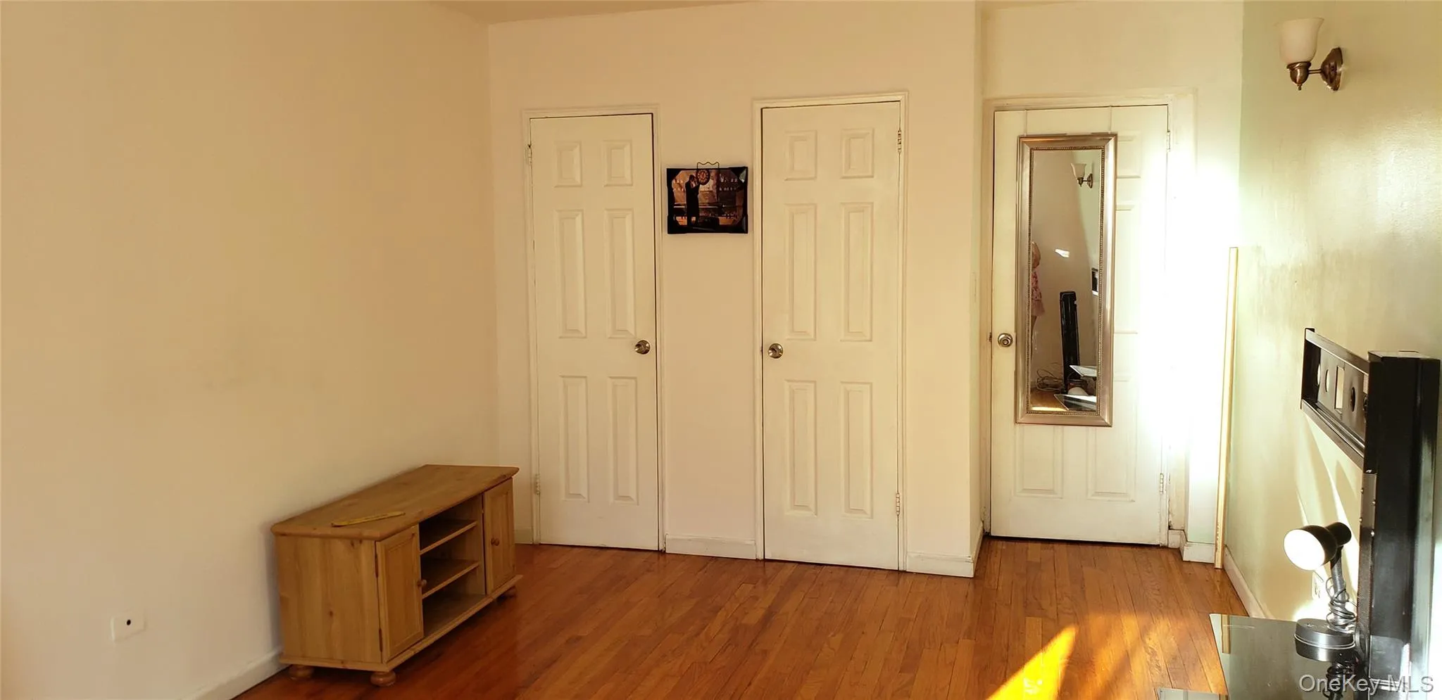 Bedroom with wood finished floors and two closets Bedroom with wood finished floors and two closets