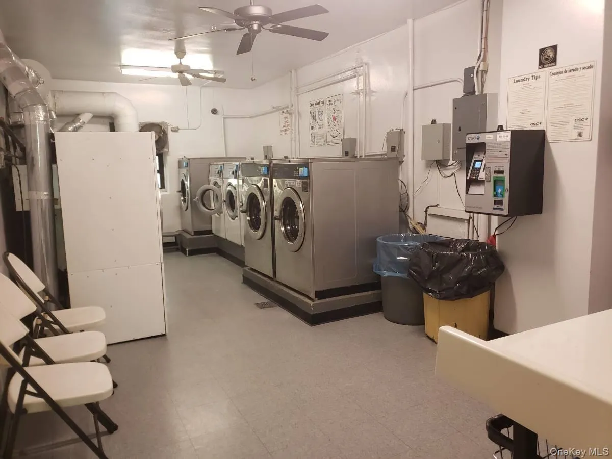 Shared laundry room with a ceiling fan, washer and clothes dryer, electric panel, and heating unit Shared laundry room with a ceiling fan, washer and clothes dryer, electric panel, and heating unit