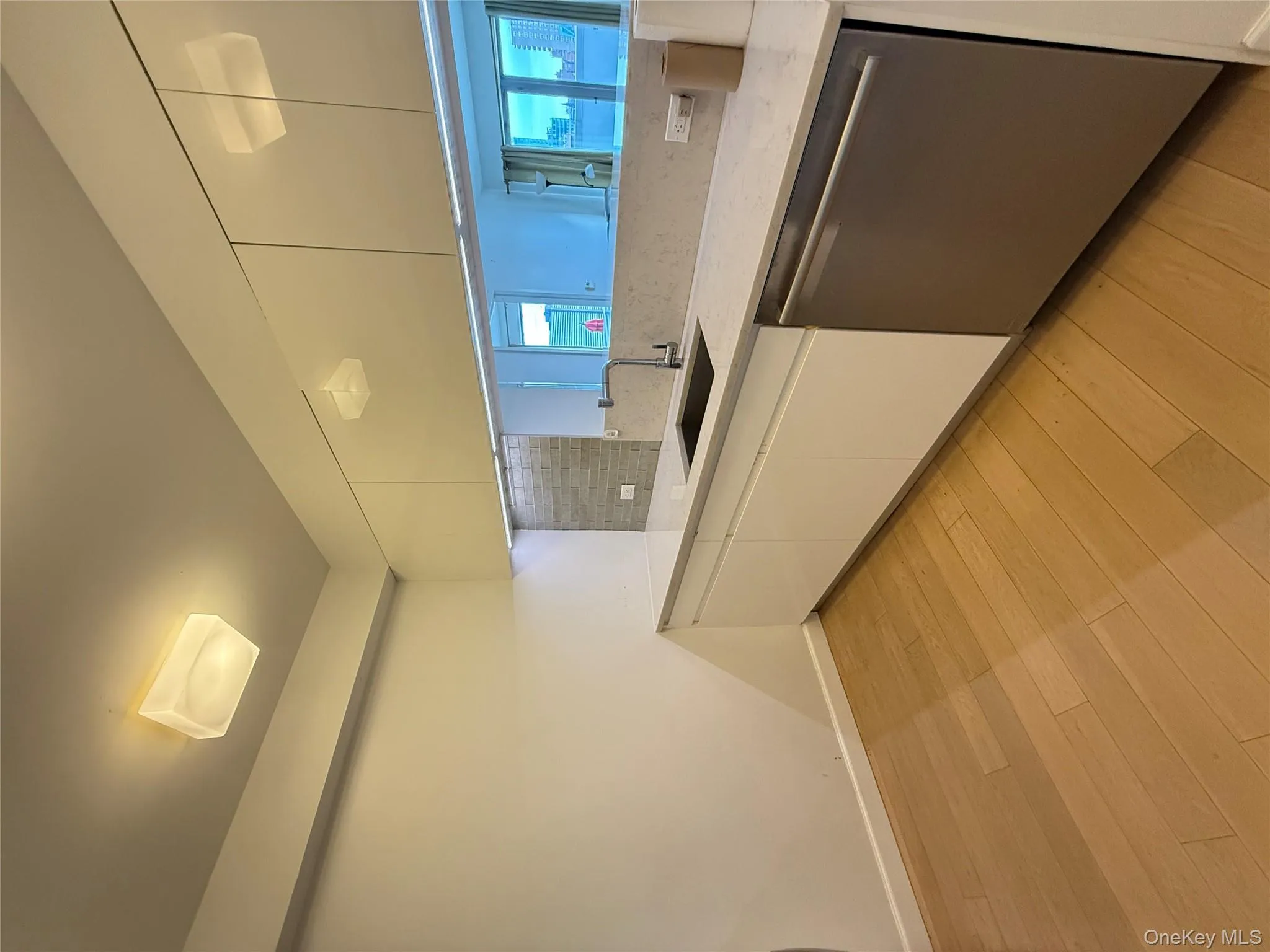 Kitchen featuring white cabinetry, modern cabinets, light stone countertops, and dishwashing machine Kitchen featuring white cabinetry, modern cabinets, light stone countertops, and dishwashing machine