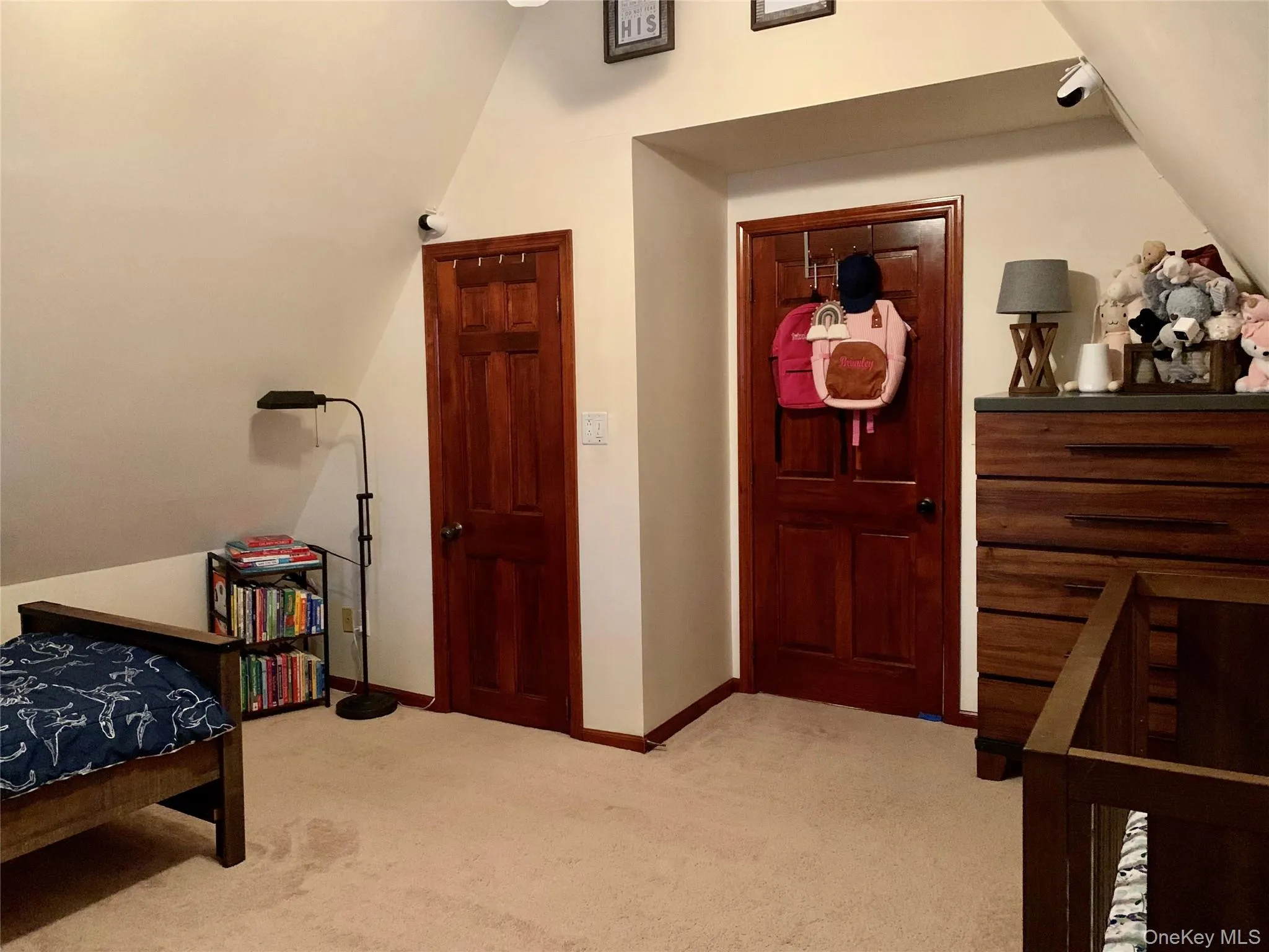 Bedroom featuring vaulted ceiling and light carpet Bedroom featuring vaulted ceiling and light carpet