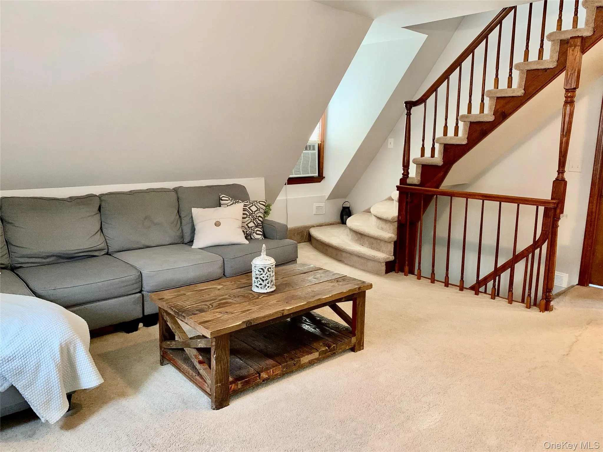 Living room featuring carpet flooring and stairway Living room featuring carpet flooring and stairway