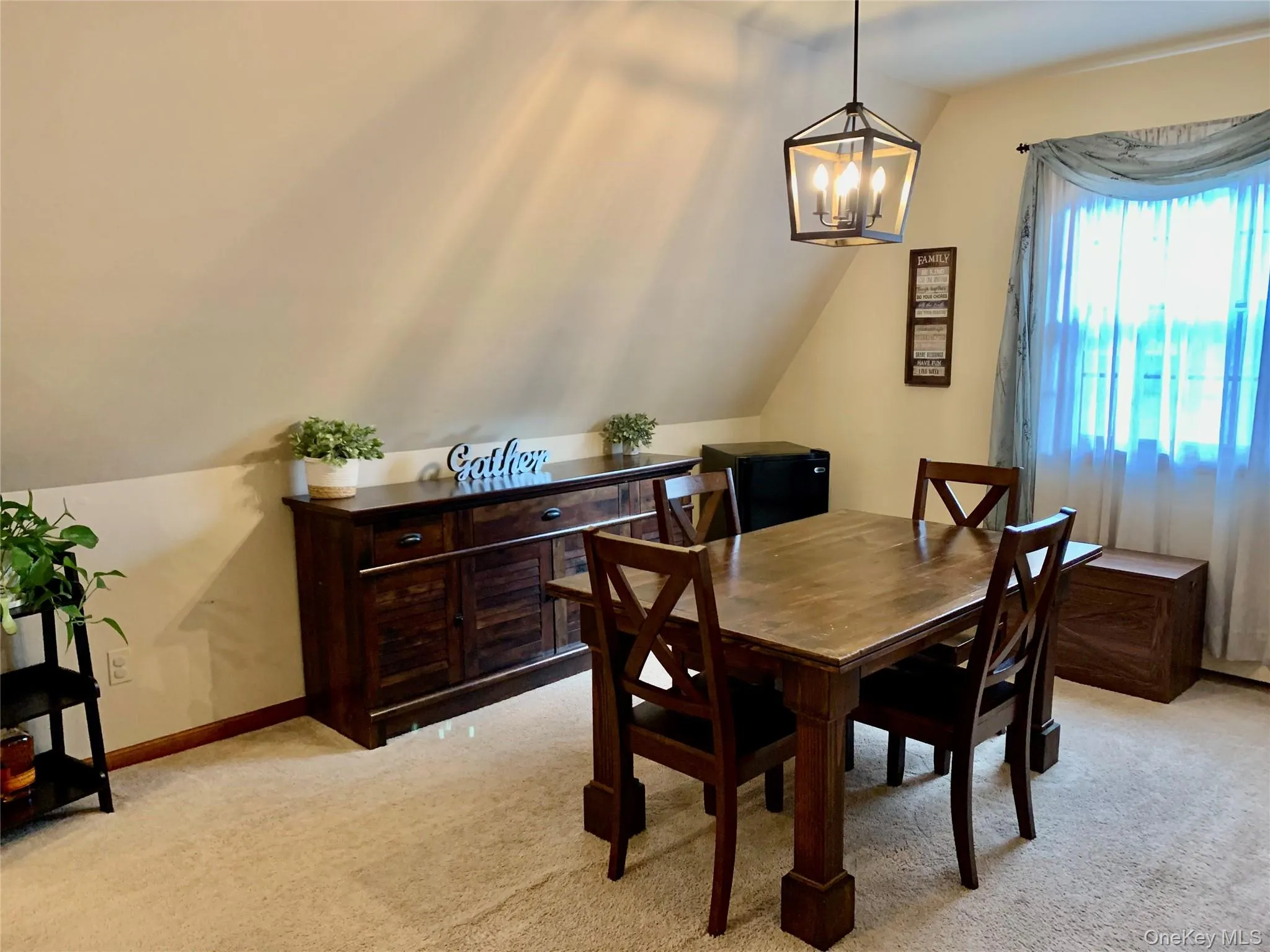 Dining area with light carpet, vaulted ceiling, and a chandelier Dining area with light carpet, vaulted ceiling, and a chandelier