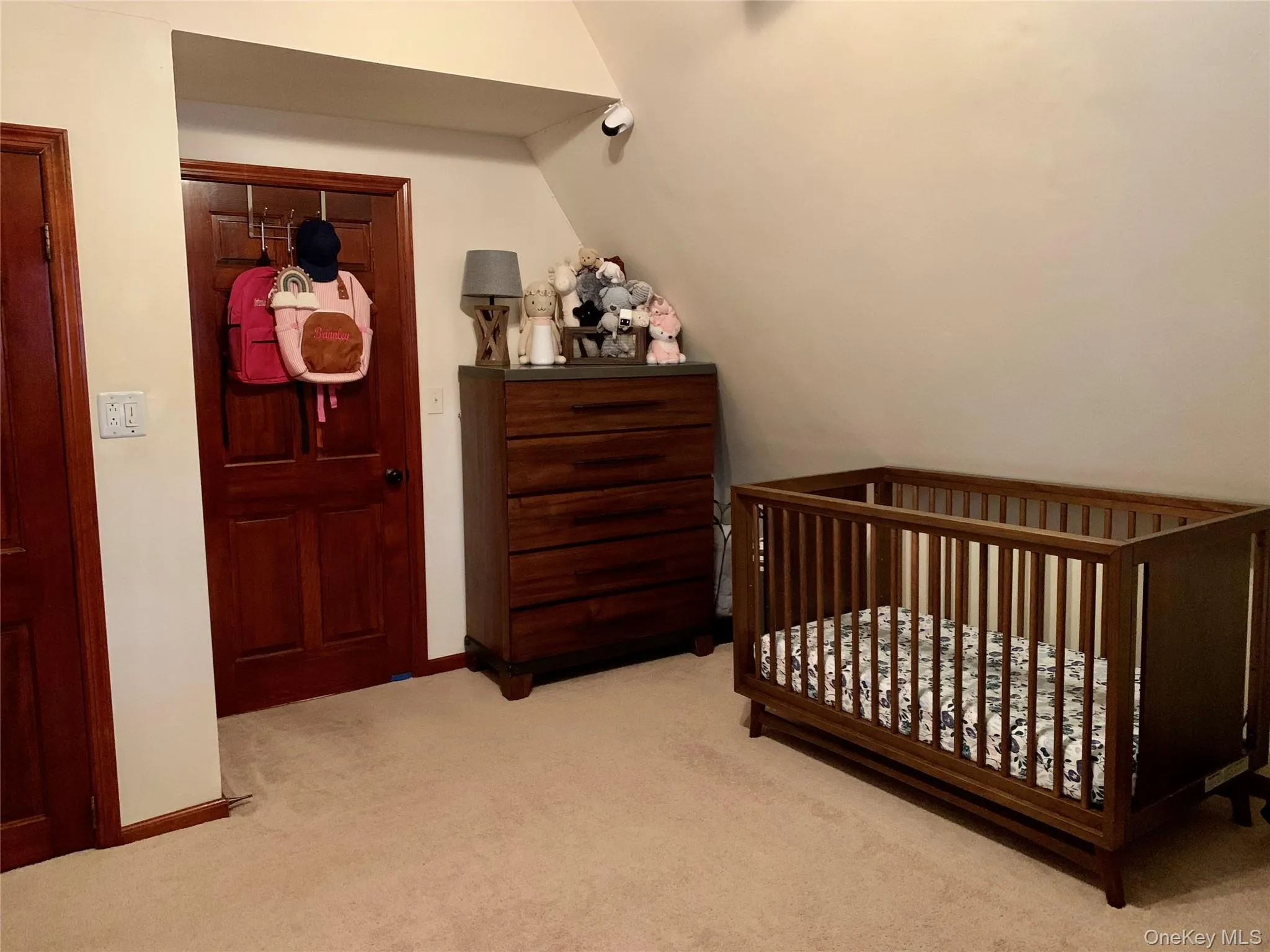 Bedroom with carpet floors, a nursery area, and lofted ceiling Bedroom with carpet floors, a nursery area, and lofted ceiling