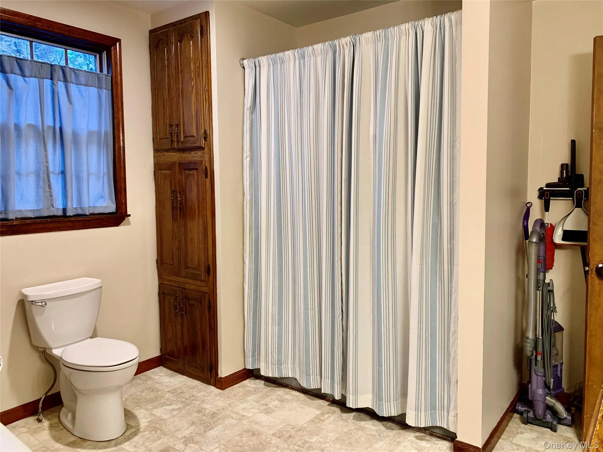 Bathroom featuring a shower with shower curtain and baseboards Bathroom featuring a shower with shower curtain and baseboards
