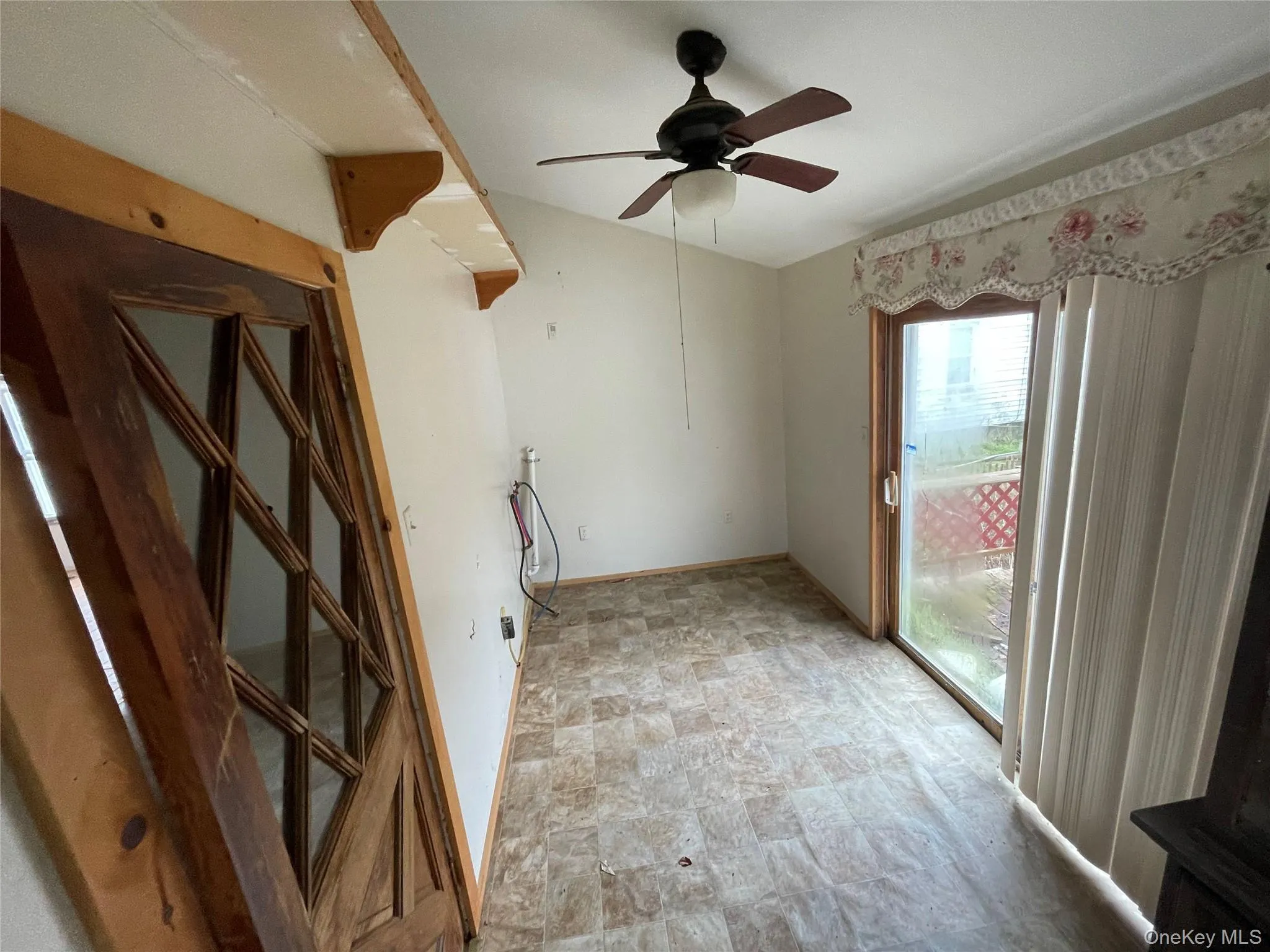 Unfurnished room with ceiling fan and stone finish flooring Unfurnished room with ceiling fan and stone finish flooring
