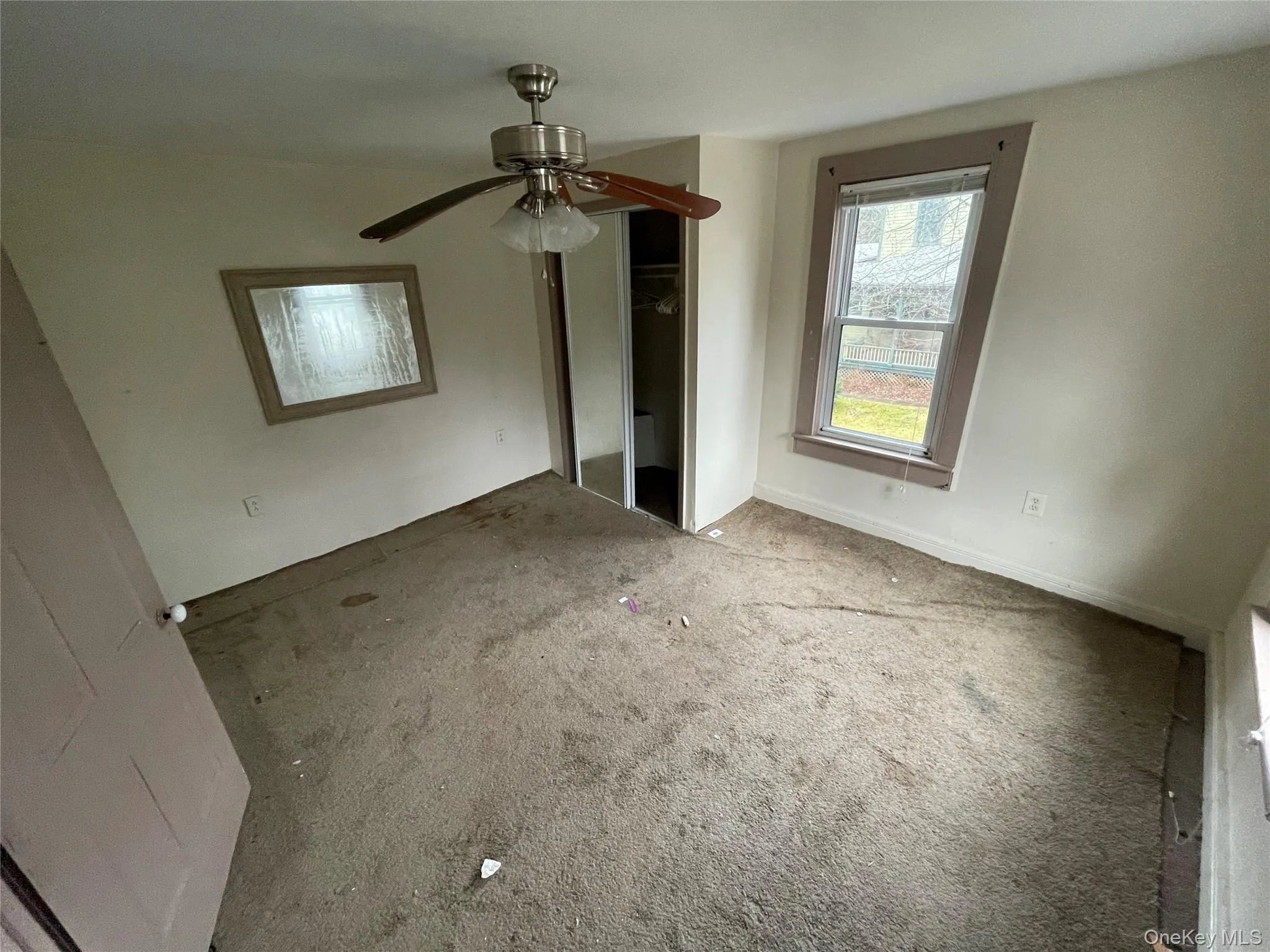 Unfurnished bedroom with a closet, ceiling fan, and carpet flooring Unfurnished bedroom with a closet, ceiling fan, and carpet flooring