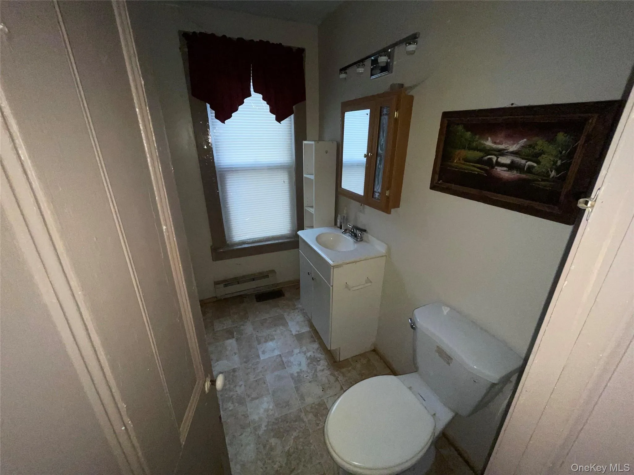 Bathroom featuring vanity and baseboard heating Bathroom featuring vanity and baseboard heating