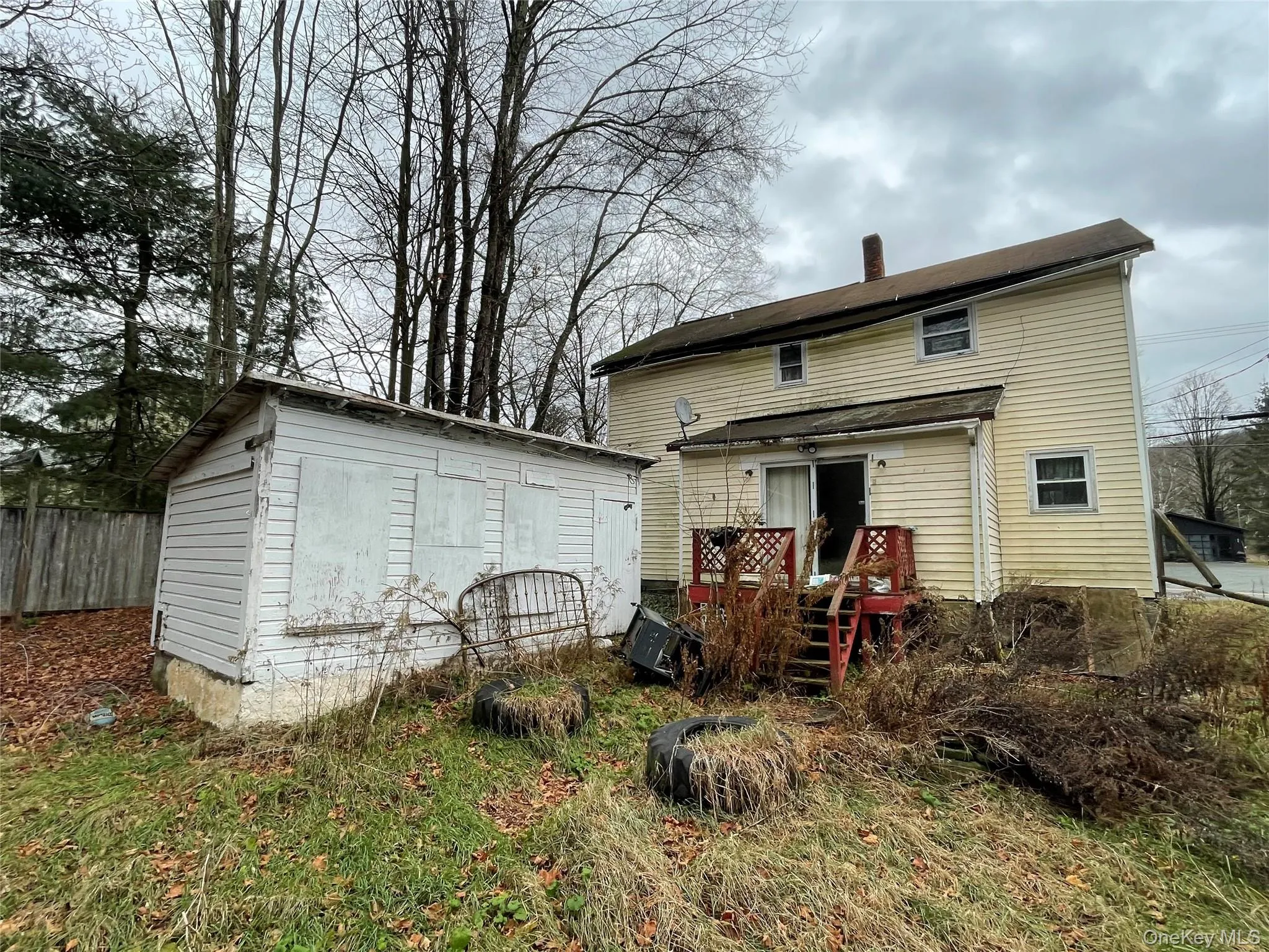 Rear view of house with a chimney and an outbuilding Rear view of house with a chimney and an outbuilding