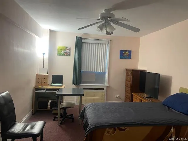 Bedroom featuring an office area, carpet, and ceiling fan Bedroom featuring an office area, carpet, and ceiling fan