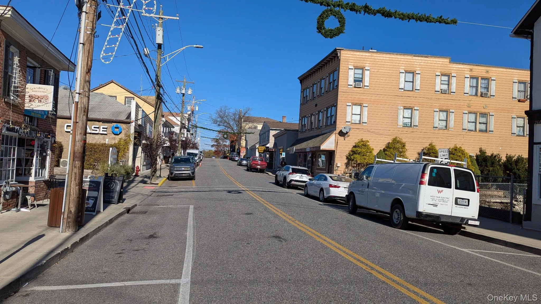 View of asphalt road featuring sidewalks, street lighting, and curbs View of asphalt road featuring sidewalks, street lighting, and curbs