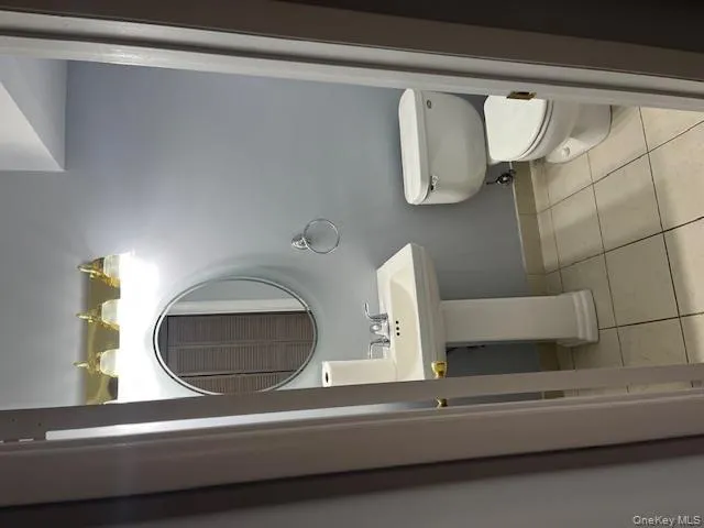 Half bathroom featuring light tile patterned floors and toilet Half bathroom featuring light tile patterned floors and toilet