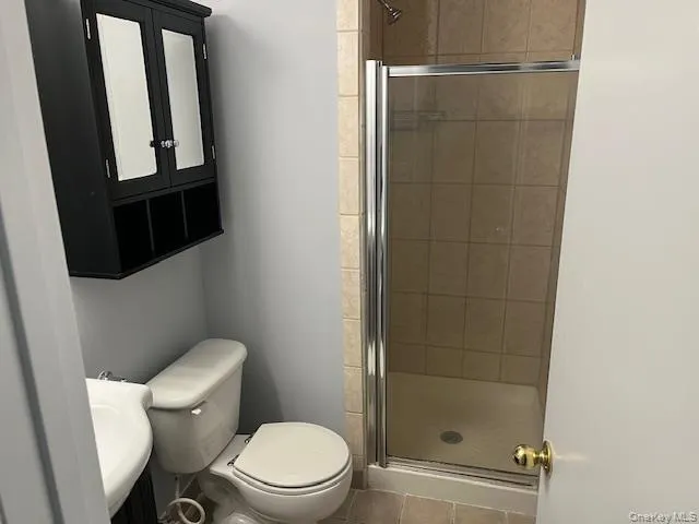Full bathroom featuring a stall shower and tile patterned flooring Full bathroom featuring a stall shower and tile patterned flooring