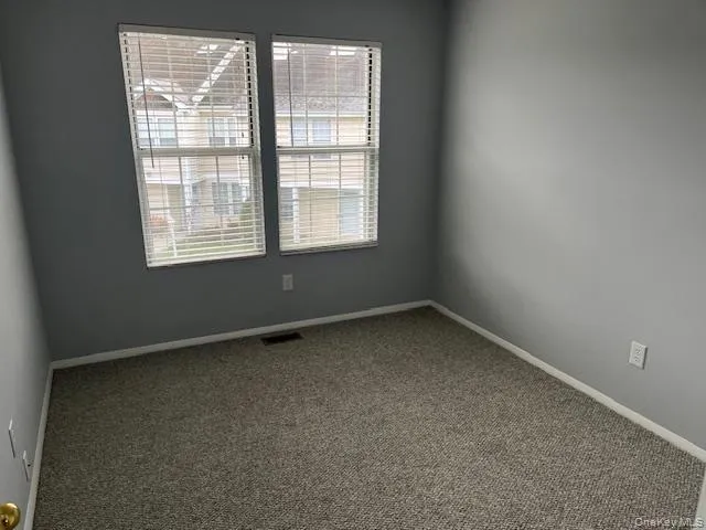 Spare room featuring carpet floors and baseboards Spare room featuring carpet floors and baseboards