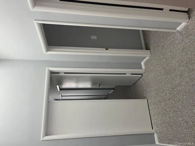 Hallway featuring light colored carpet and baseboards Hallway featuring light colored carpet and baseboards