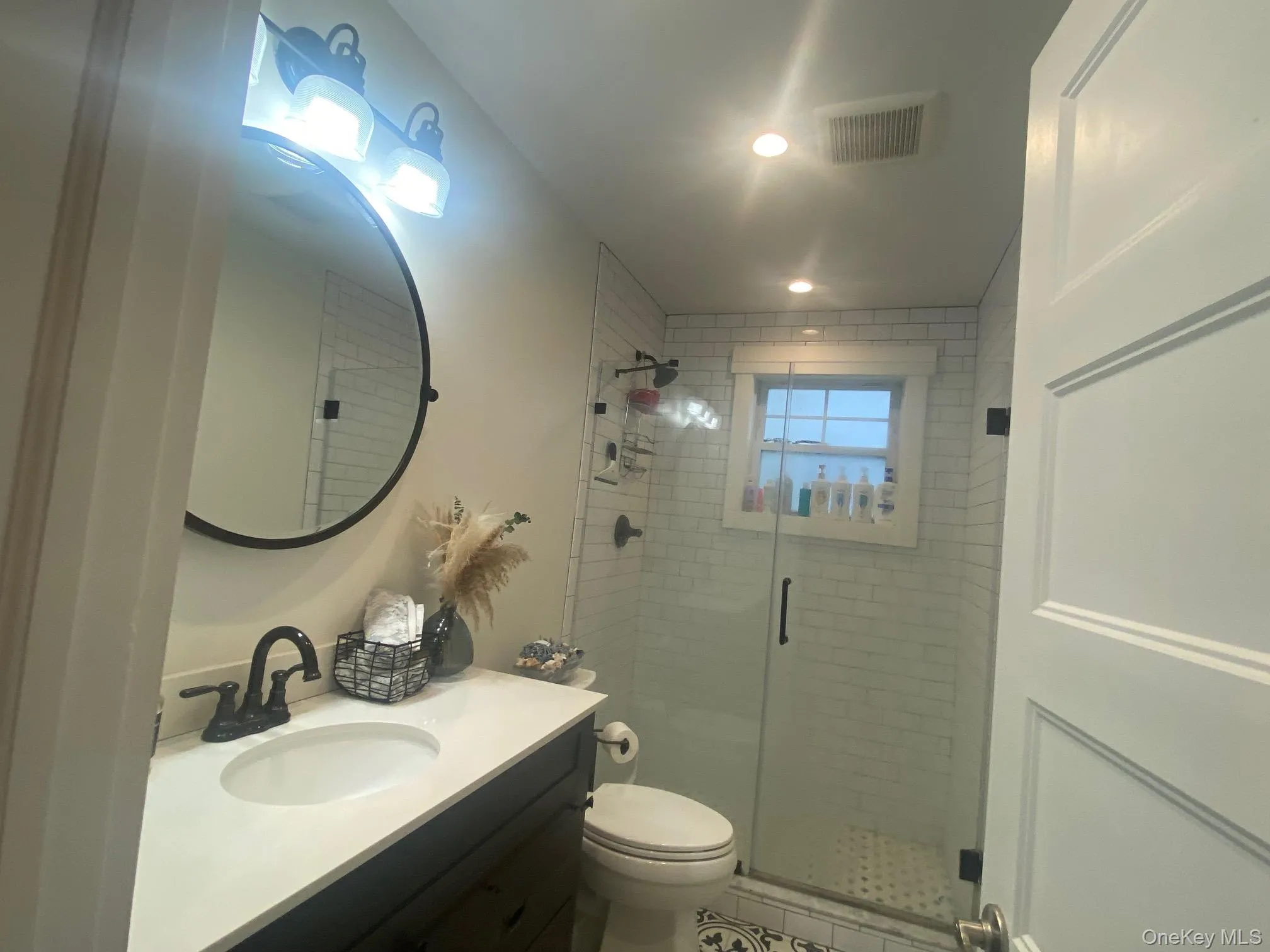 Bathroom with a shower stall, vanity, and recessed lighting Bathroom with a shower stall, vanity, and recessed lighting
