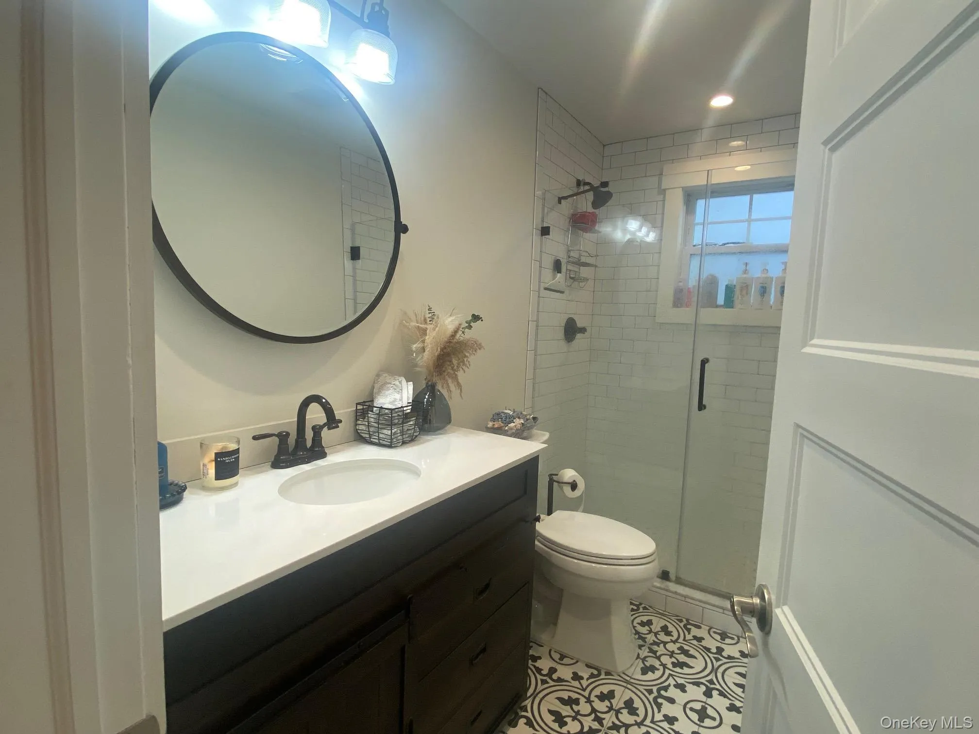 Bathroom with vanity, a shower stall, and light tile patterned floors Bathroom with vanity, a shower stall, and light tile patterned floors