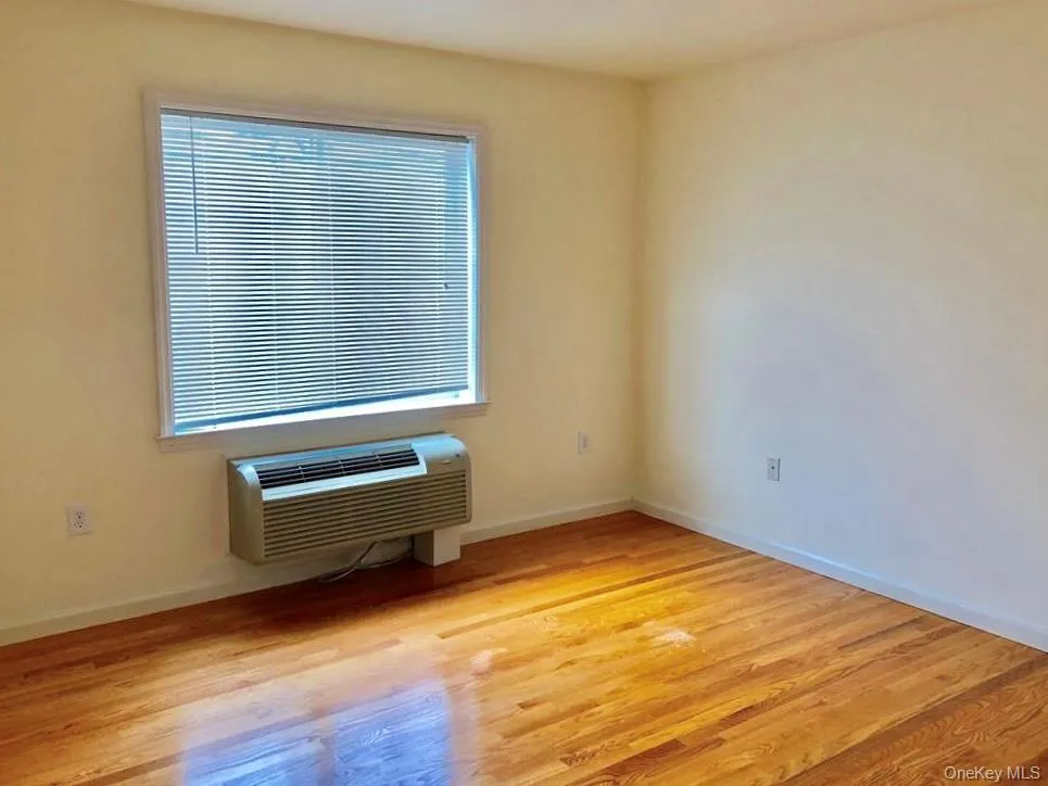 Spare room featuring light wood-style floors and a wall mounted AC Spare room featuring light wood-style floors and a wall mounted AC