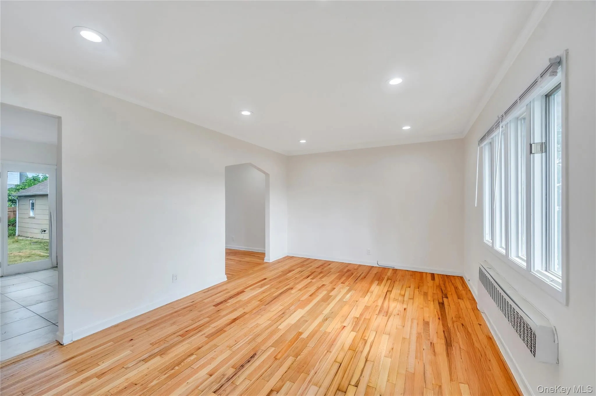 Unfurnished room featuring crown molding, radiator, light wood-style flooring, and recessed lighting Unfurnished room featuring crown molding, radiator, light wood-style flooring, and recessed lighting
