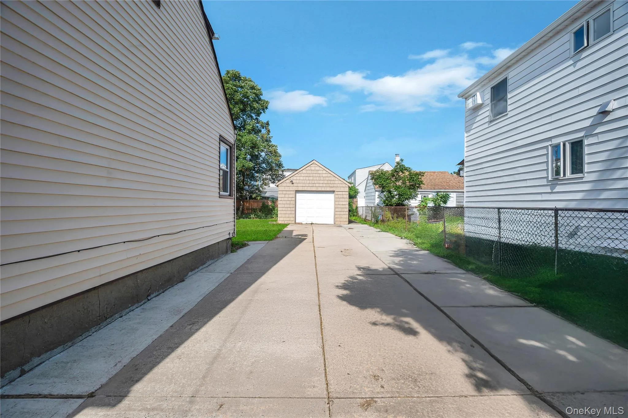 View of side of property with a garage, an outbuilding, and driveway View of side of property with a garage, an outbuilding, and driveway