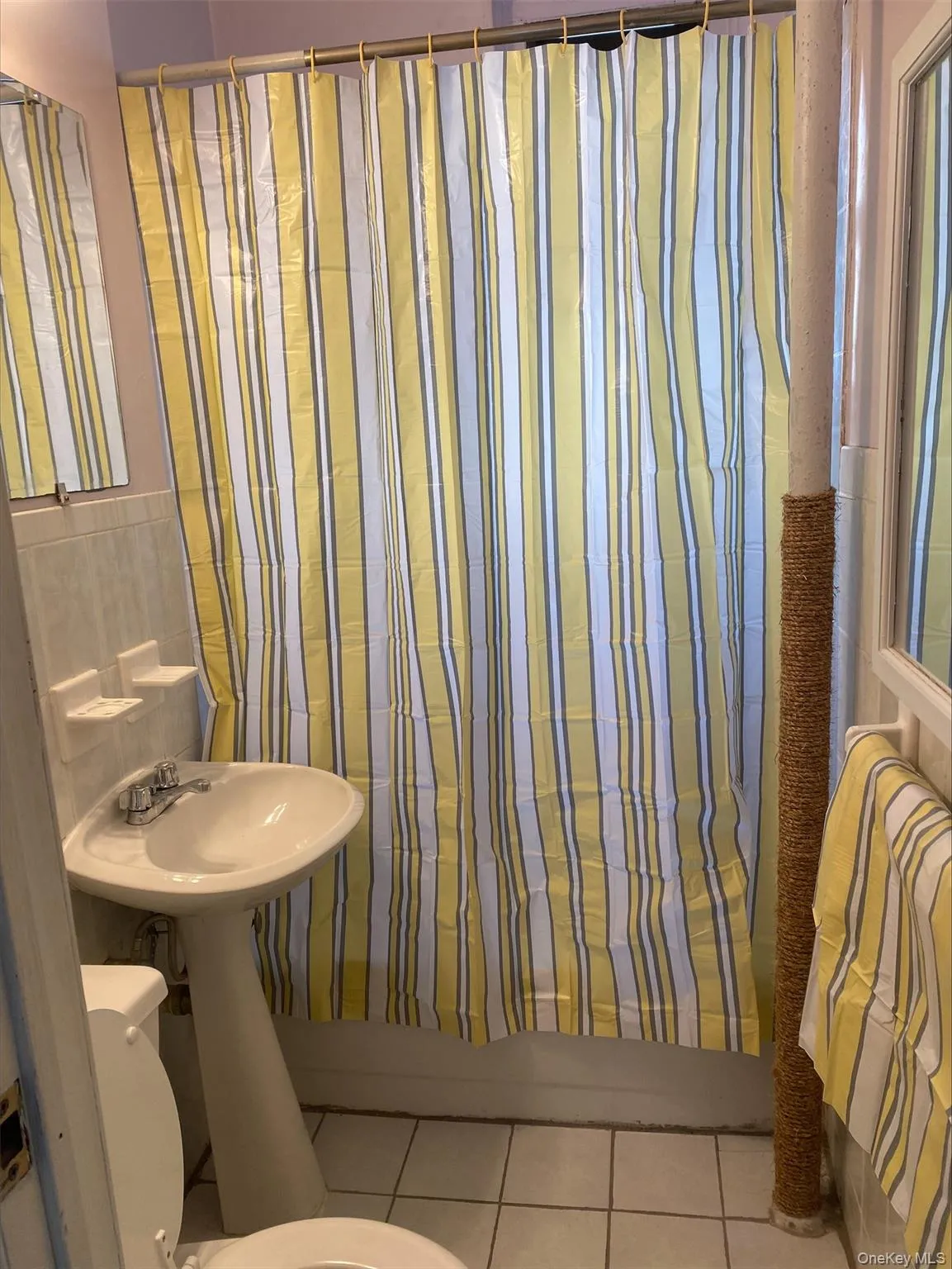 Full bathroom featuring shower / bathtub combination with curtain and light tile patterned floors Full bathroom featuring shower / bathtub combination with curtain and light tile patterned floors