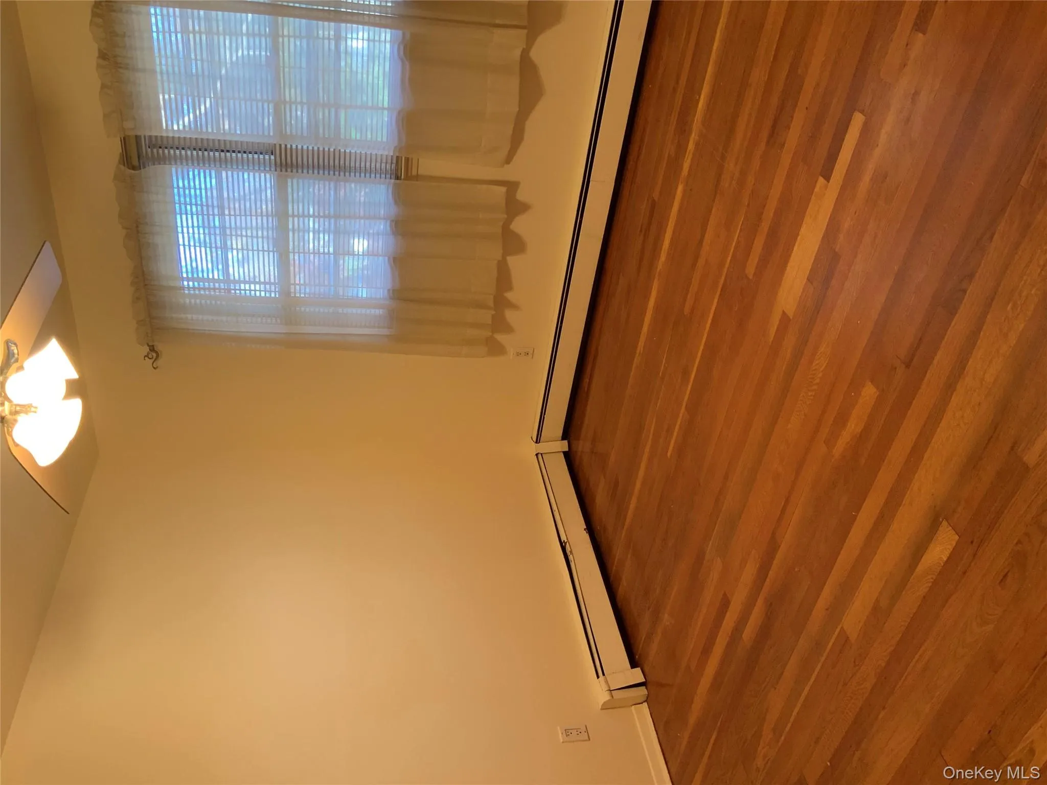 Unfurnished room with baseboard heating, dark wood-type flooring, and ceiling fan Unfurnished room with baseboard heating, dark wood-type flooring, and ceiling fan