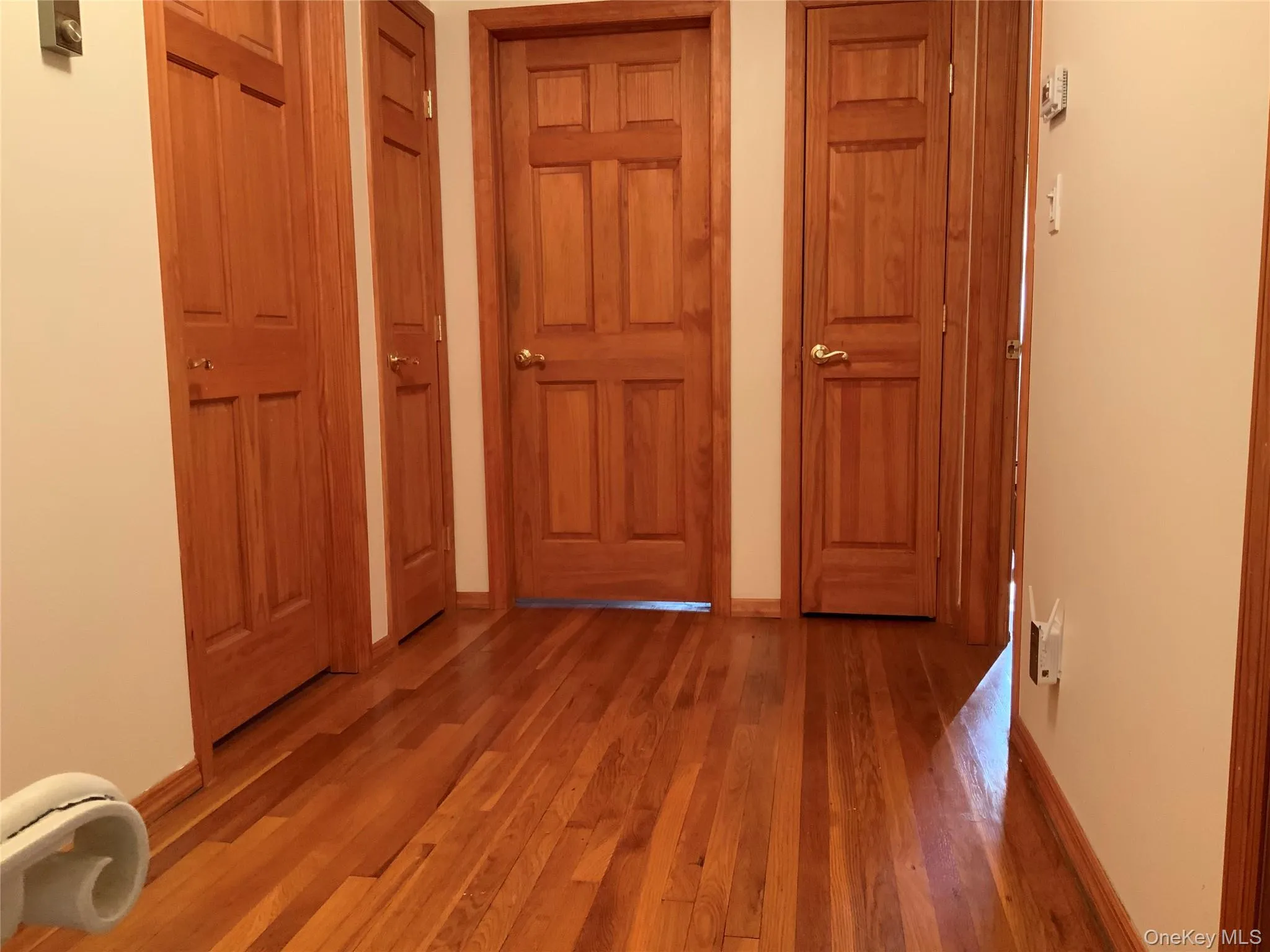 Hall featuring wood-type flooring and baseboards Hall featuring wood-type flooring and baseboards