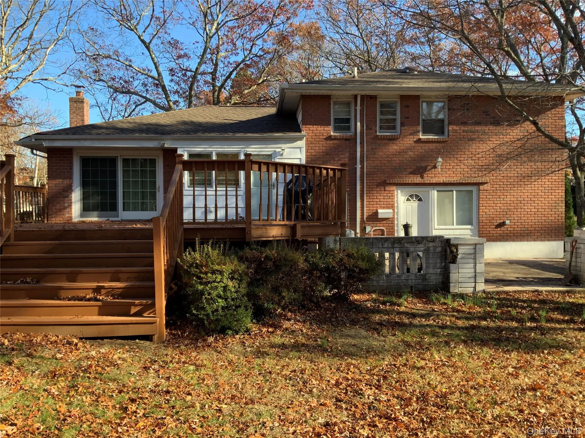 Rear view of house featuring brick siding, stairs, a chimney, and a wooden deck Rear view of house featuring brick siding, stairs, a chimney, and a wooden deck