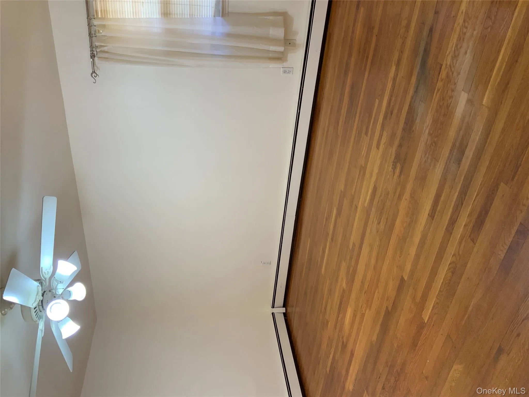 Unfurnished room with dark wood-type flooring and a baseboard radiator Unfurnished room with dark wood-type flooring and a baseboard radiator