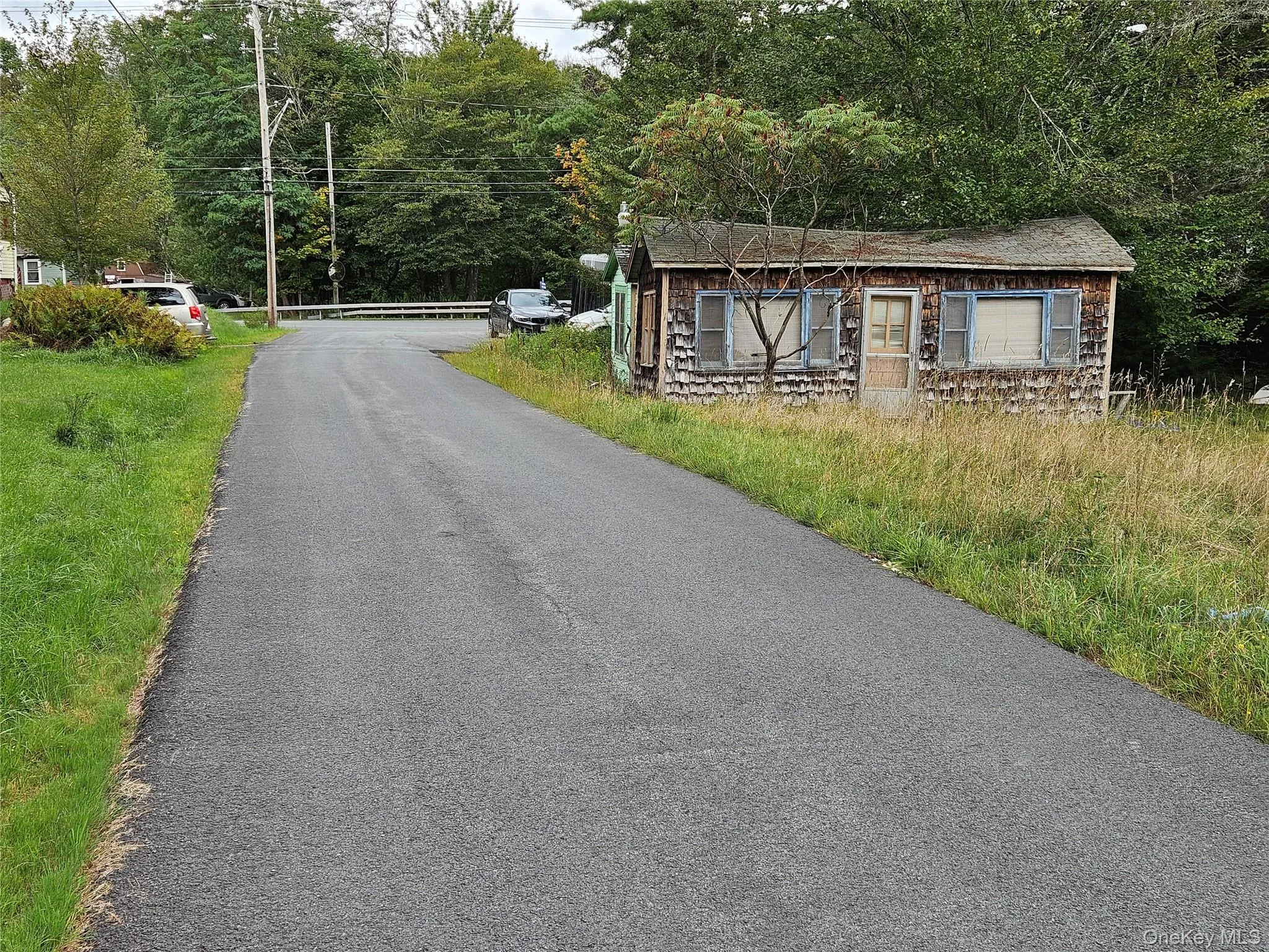 View of asphalt road and rundown cottages View of asphalt road and rundown cottages