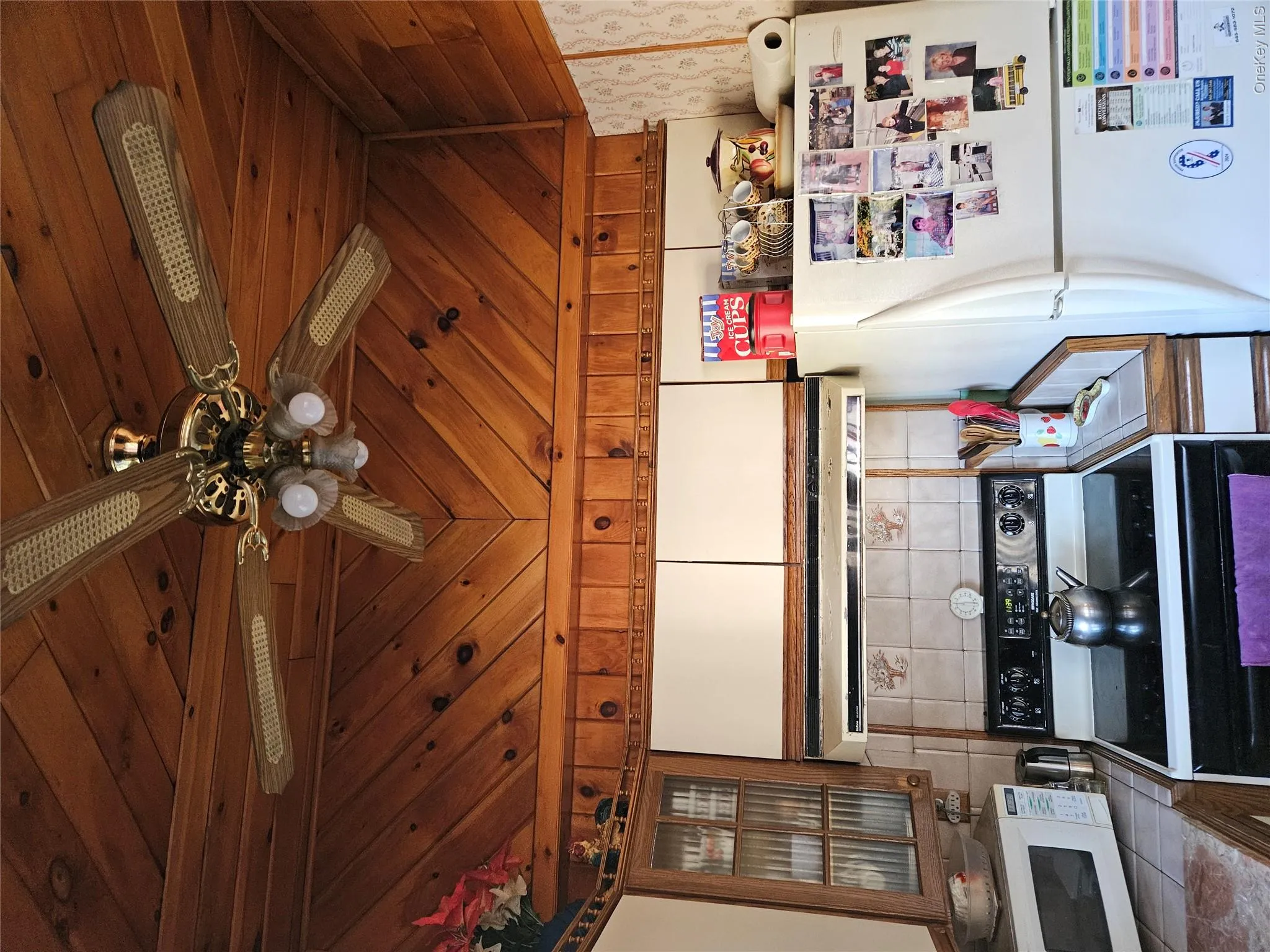 Kitchen featuring range, fridge, wood ceiling, brown cabinetry, and extractor fan Kitchen featuring range, fridge, wood ceiling, brown cabinetry, and extractor fan