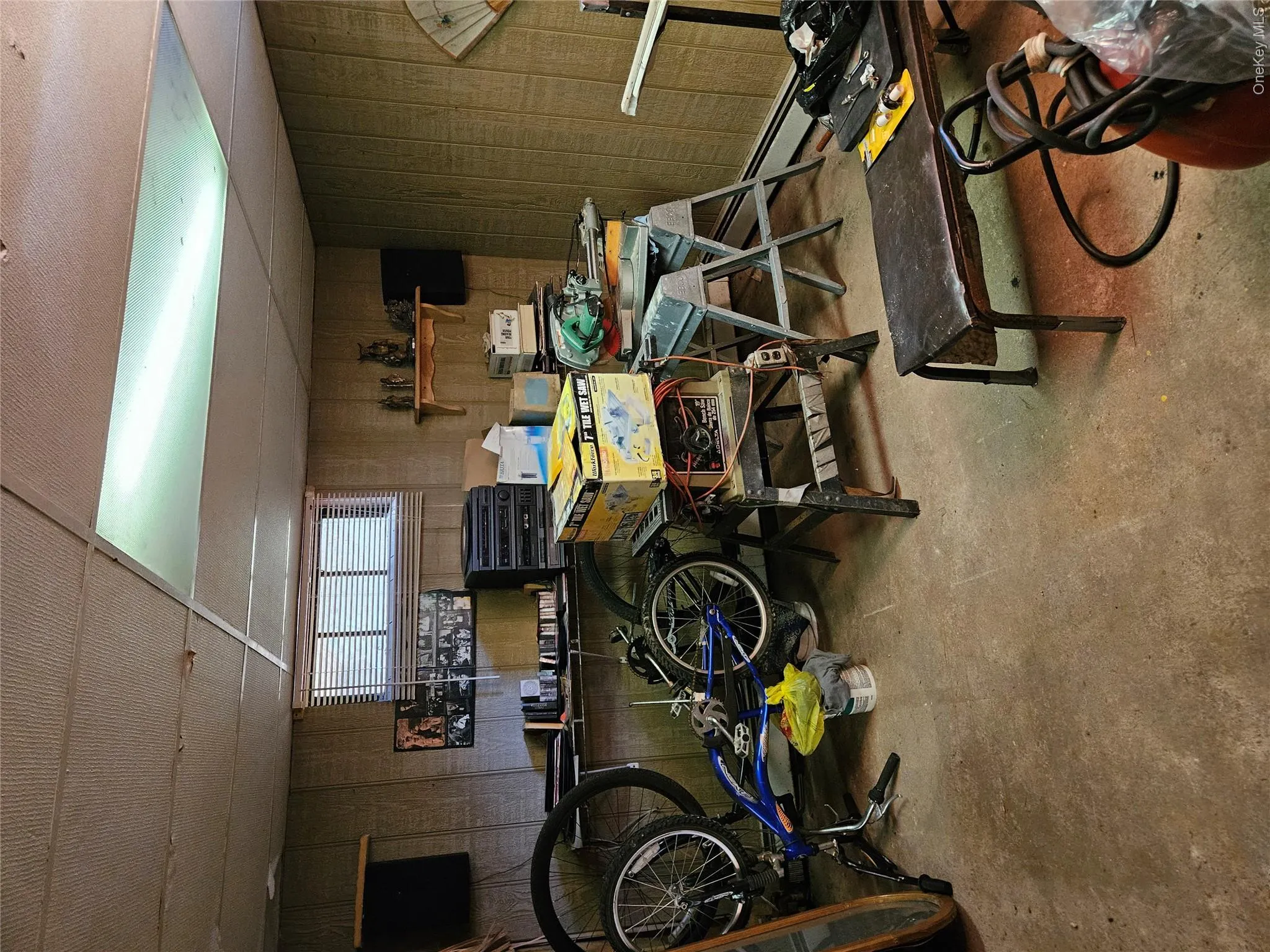 Basement featuring workshop, a drop ceiling, and a baseboard radiator Basement featuring workshop, a drop ceiling, and a baseboard radiator