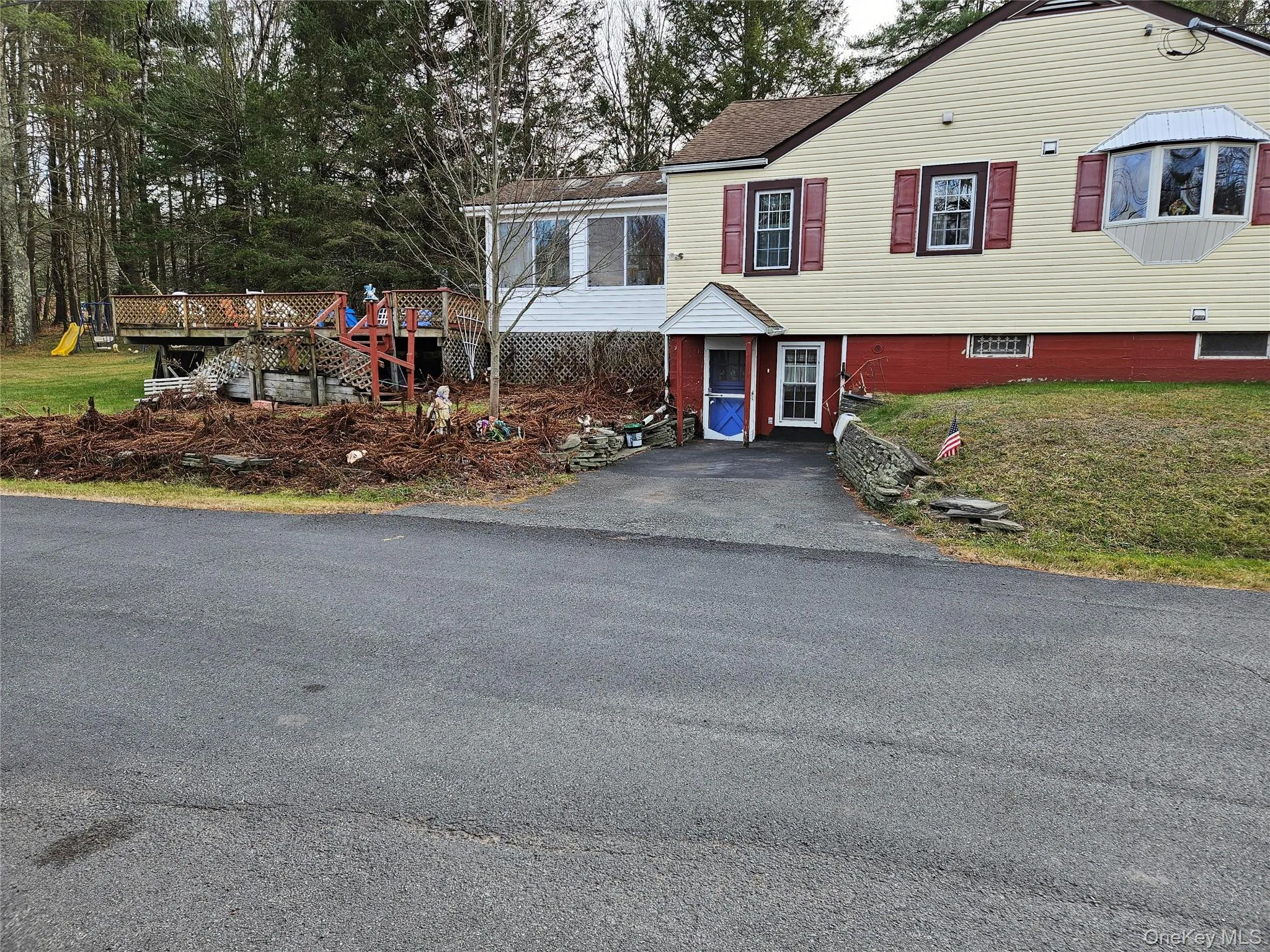 Side View of property featuring a sideyard, a wooden deck, asphalt driveway, and a deck in backyard Side View of property featuring a sideyard, a wooden deck, asphalt driveway, and a deck in backyard